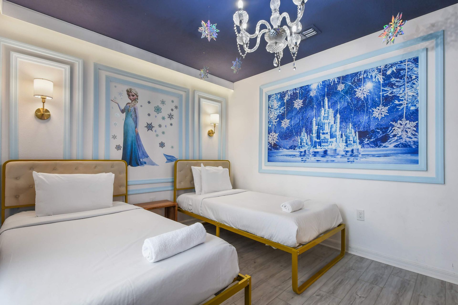 Whimsical frozen-themed room with twin beds, snowflake decor, and royal touches.
