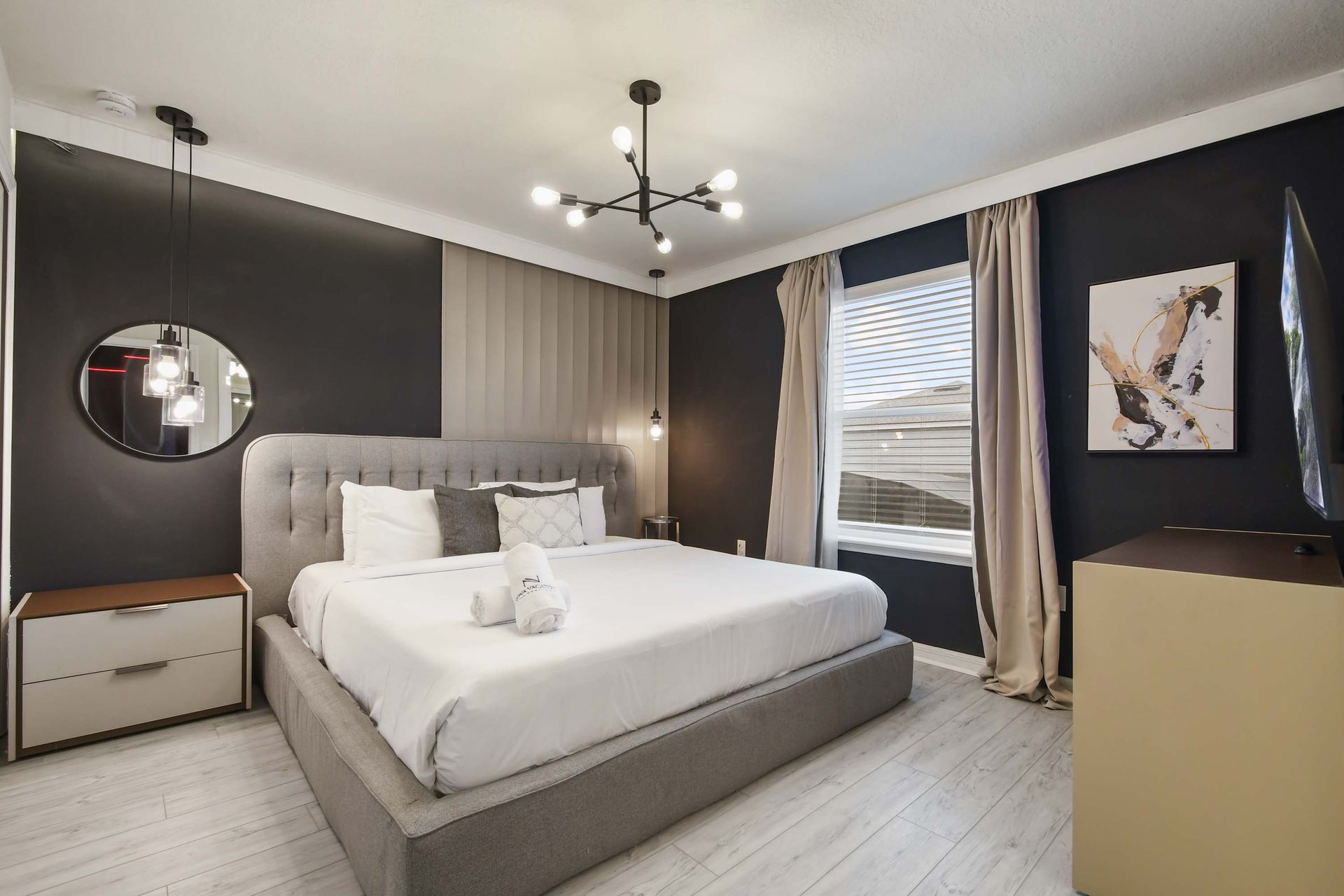 Stylish modern bedroom with king bed, bold accent wall, and contemporary lighting.