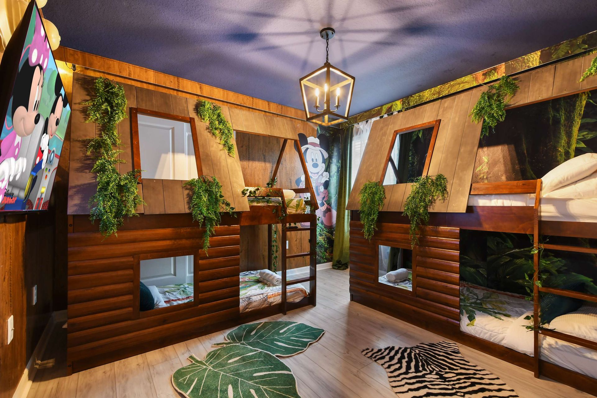 Jungle-themed bunk room with custom treehouse beds, leafy décor, and playful vibes.