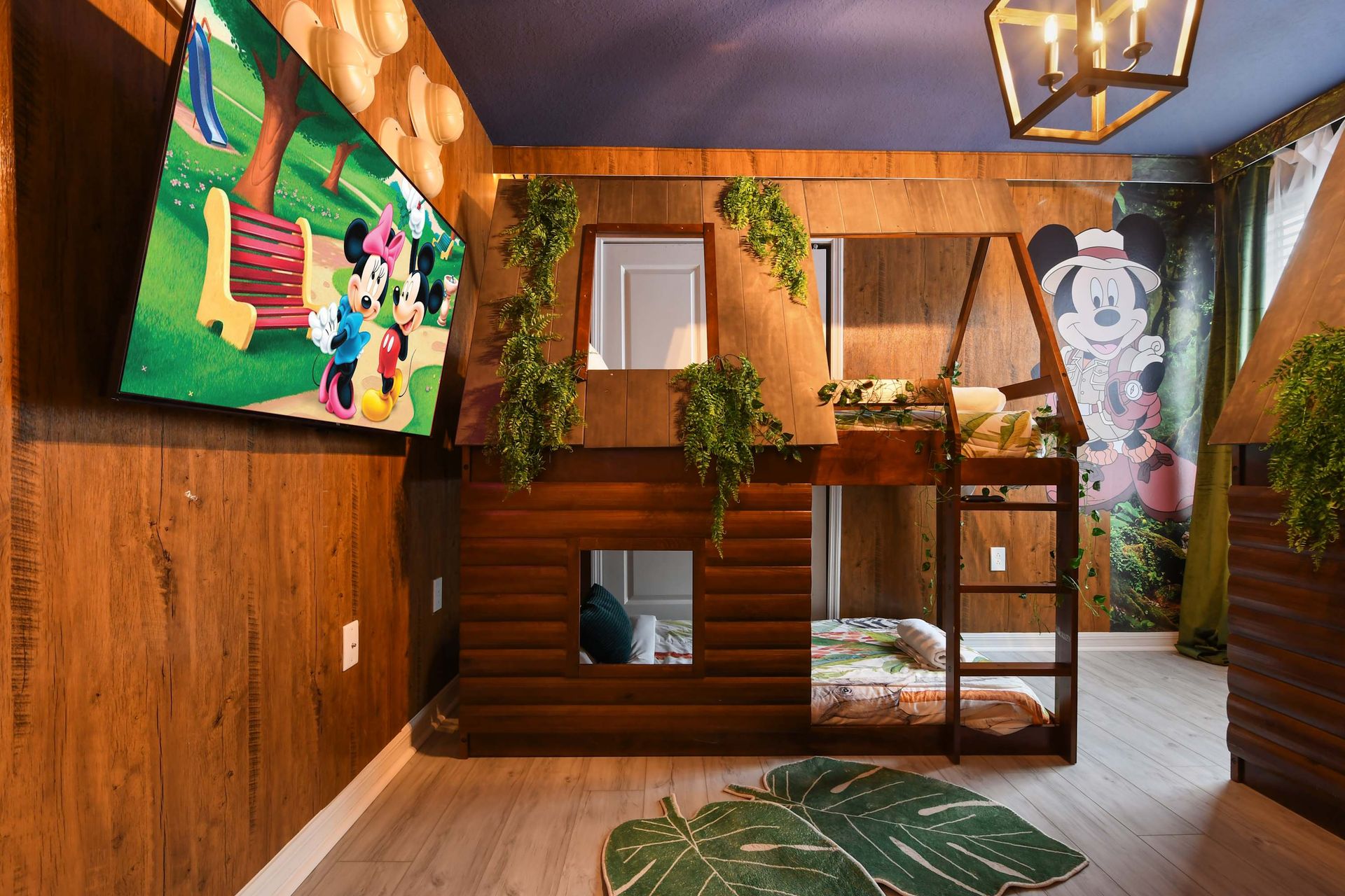 Jungle-themed bunk room with custom treehouse beds, leafy décor, and playful vibes.