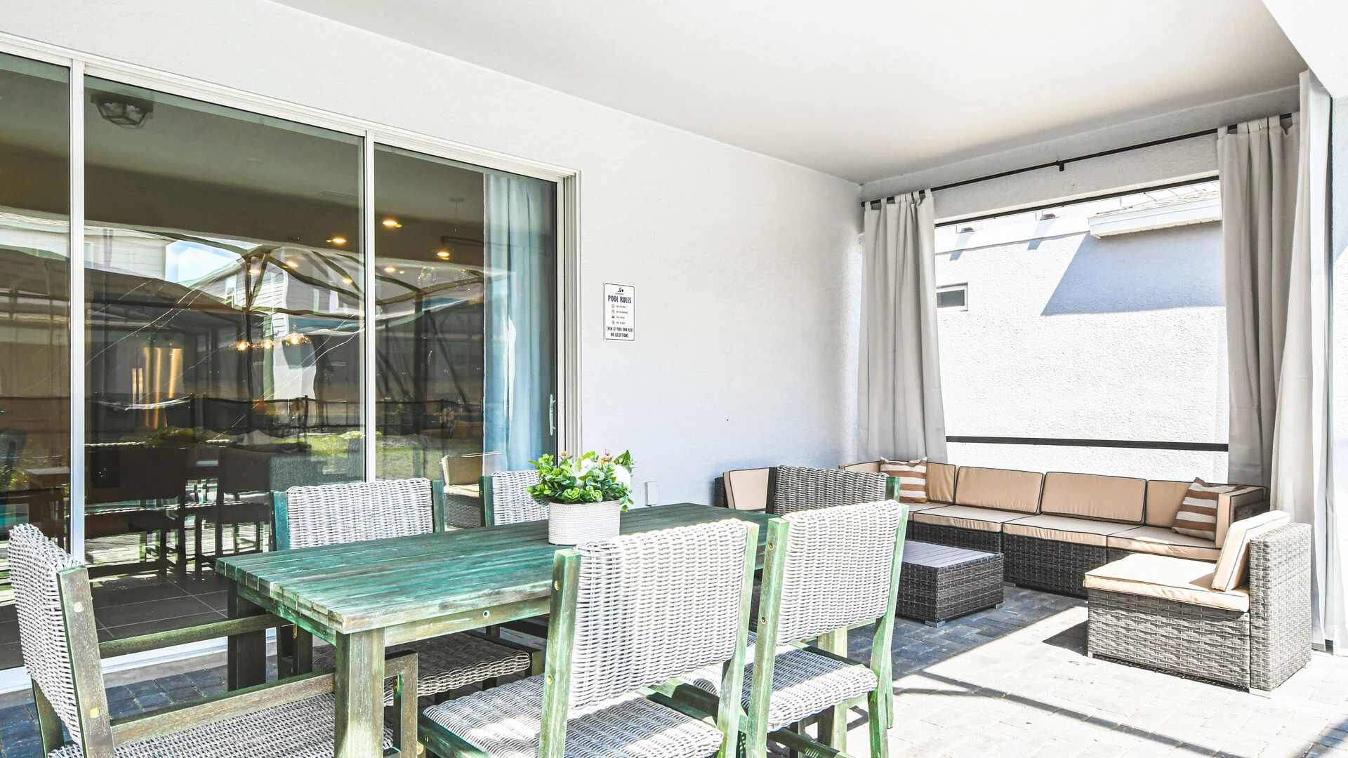 Covered outdoor lounge with dining table, cozy seating, and breezy poolside vibes.