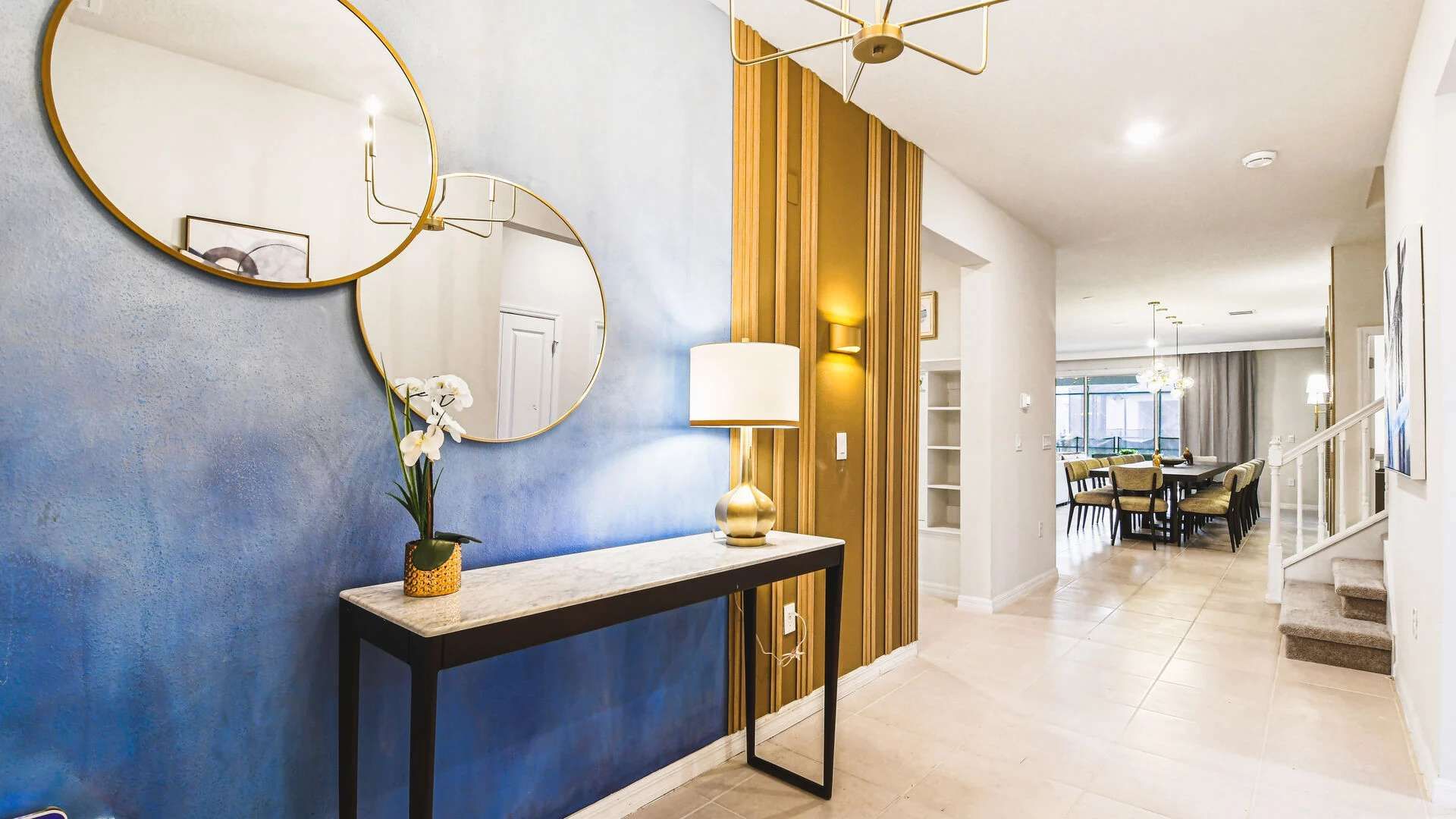 Stylish entryway with modern lighting, bold accent wall, and elegant décor touches.