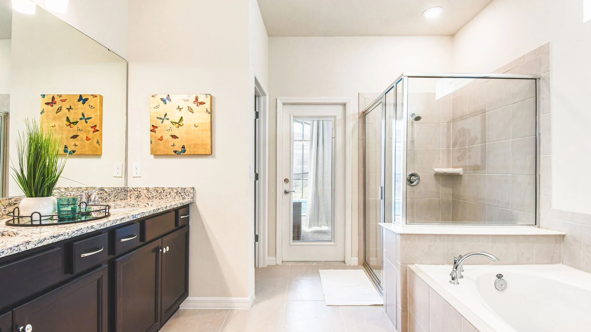 Bright spa-style bathroom with granite vanity, walk-in shower, and soaking tub.