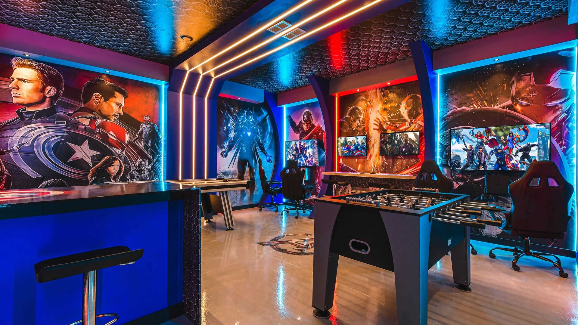 Ultimate hero-themed game room with foosball, consoles, bold lighting, and murals.