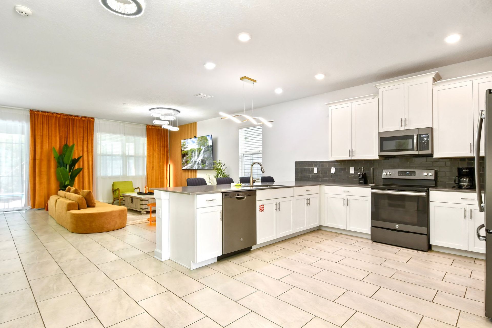 Modern open-concept kitchen with sleek finishes, spacious island, and cozy seating.