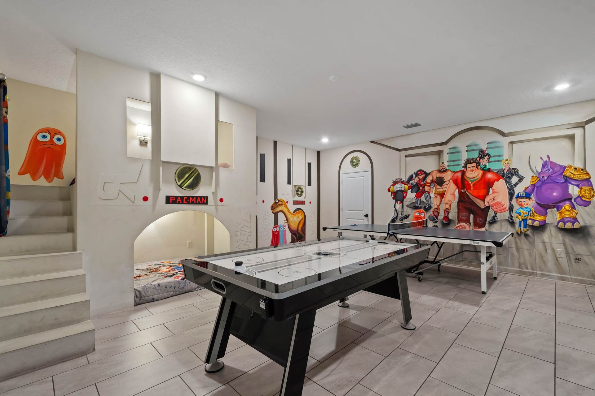 Arcade-themed game room with air hockey, ping pong, and vibrant character murals!