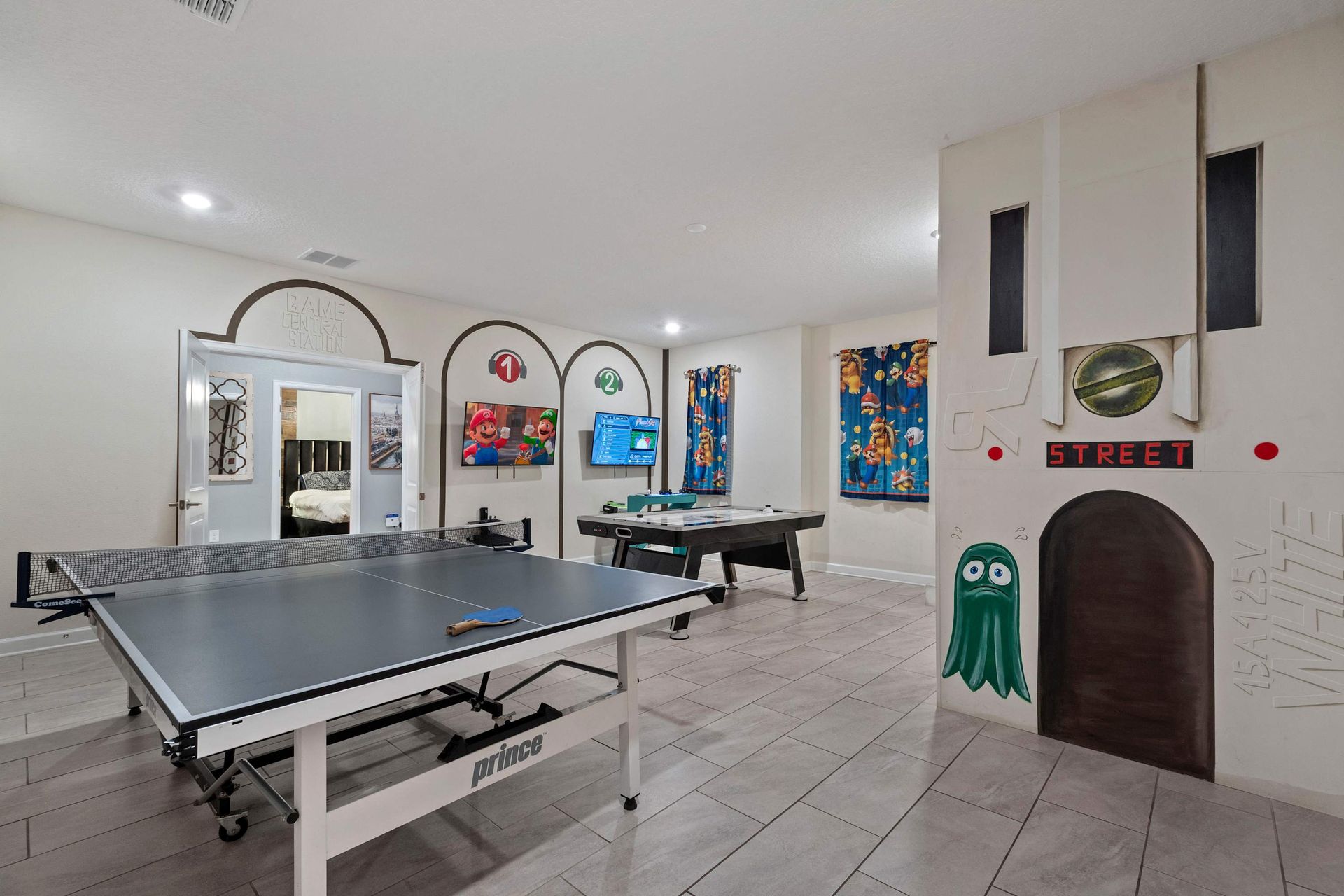 Colorful arcade-style game room with ping pong, air hockey, and retro character vibes!
