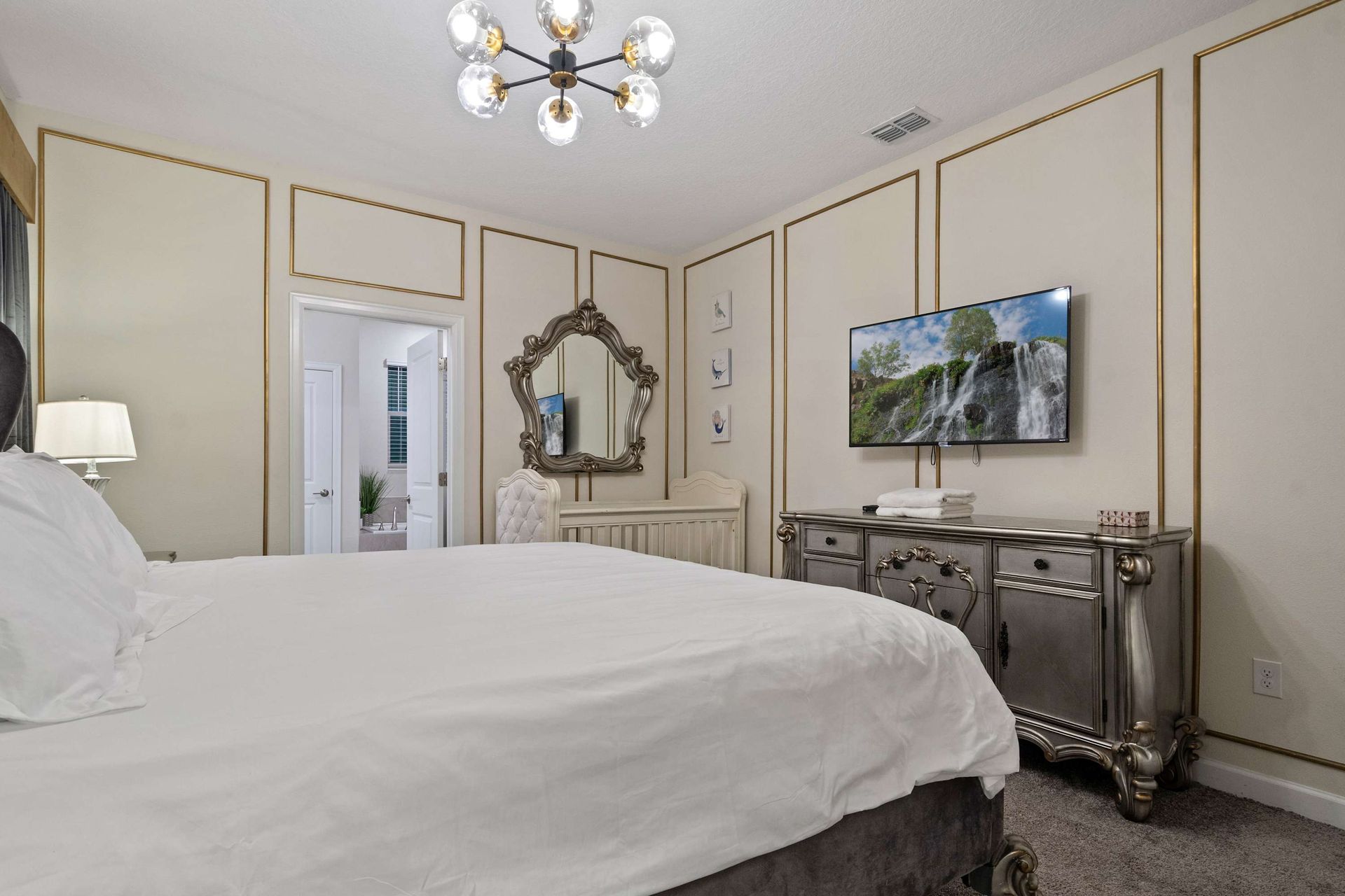 Elegant primary suite with luxe gold accents, plush bedding, and a chic modern touch!