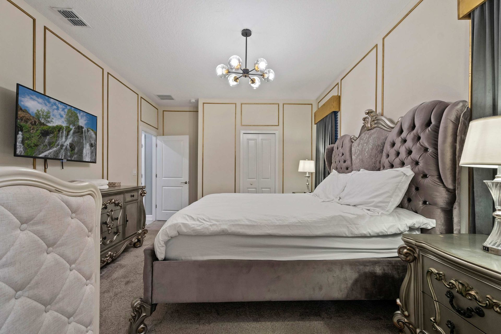 Luxurious bedroom with a regal tufted bed, elegant gold trim, and timeless charm!