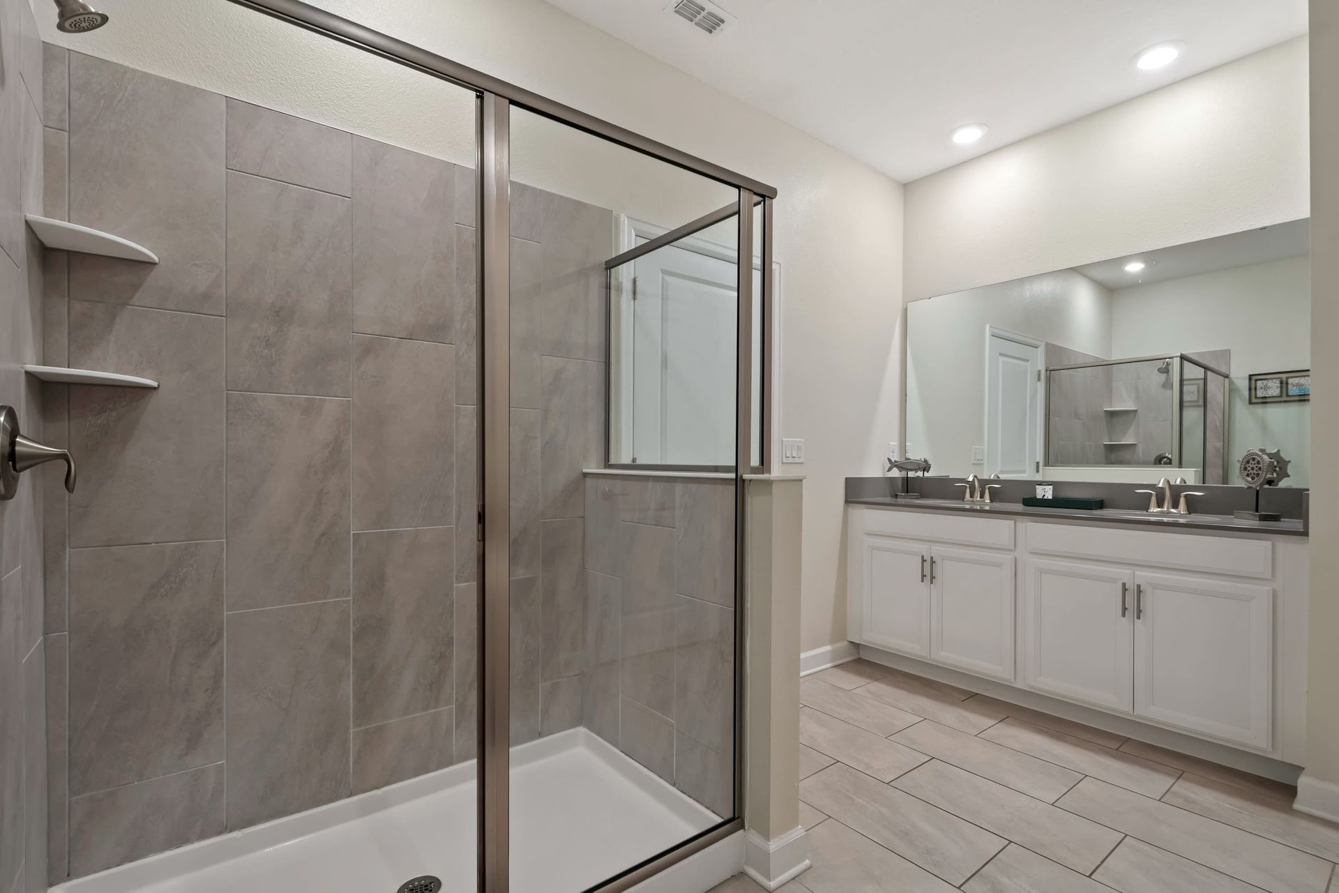 Spacious modern bathroom with a sleek walk-in shower and dual-sink vanity!