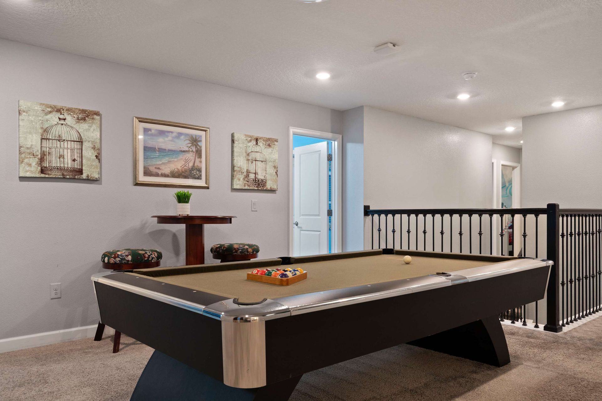 Chill upstairs in this cozy game loft featuring a sleek pool table and seating!