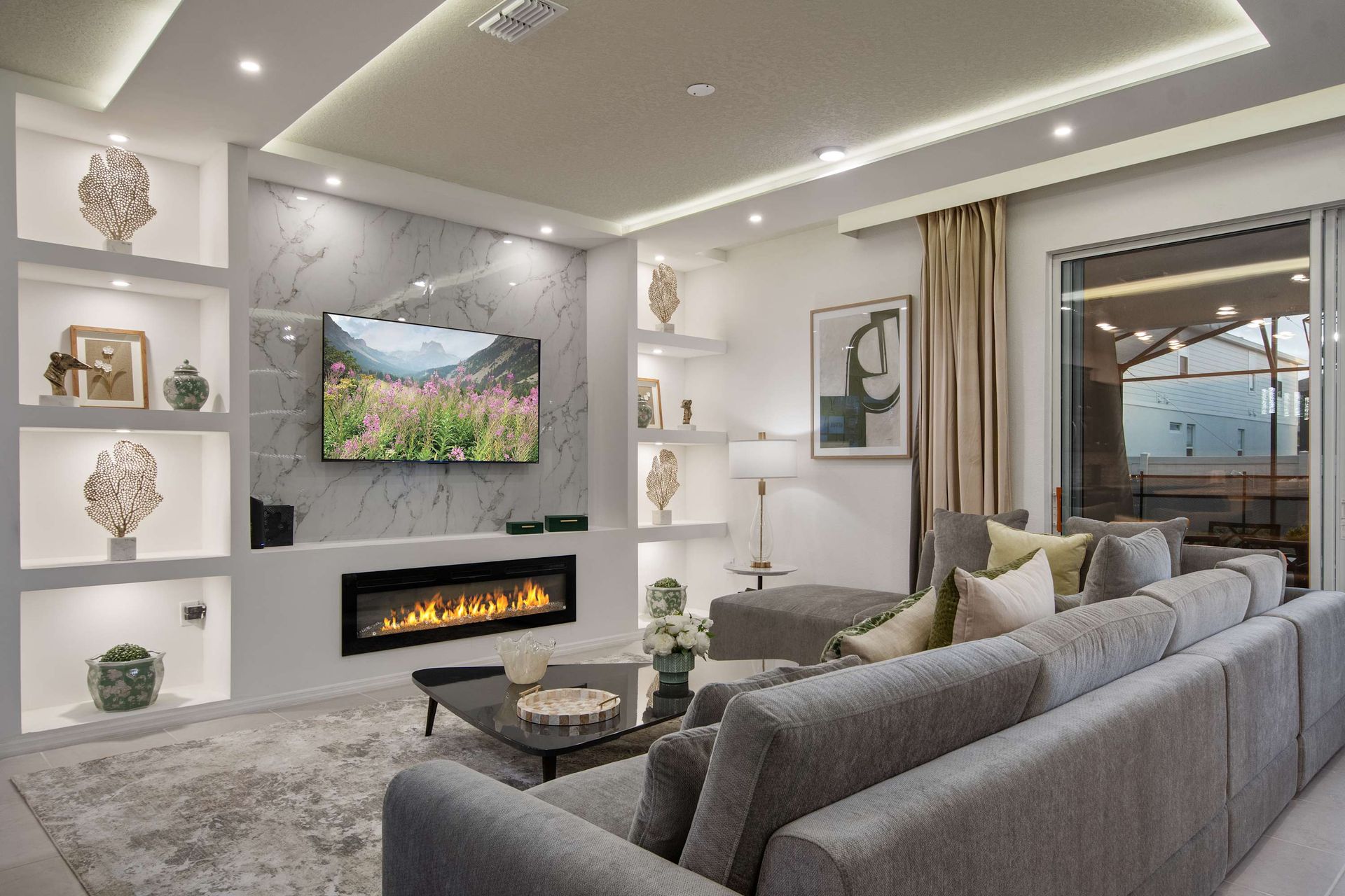 Stylish open-concept living room with fireplace, smart TV, and luxe seating.