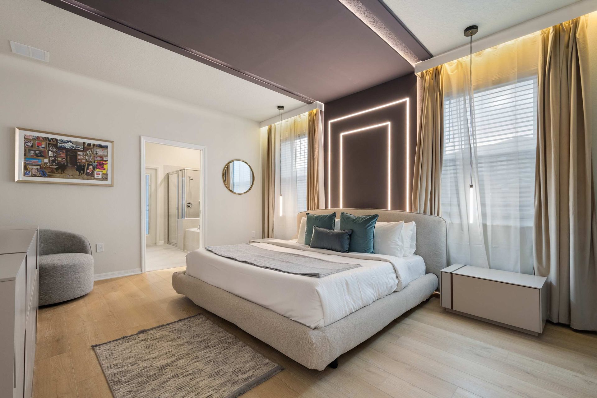 Contemporary suite with king bed, glowing accent wall, and spa-style bathroom.