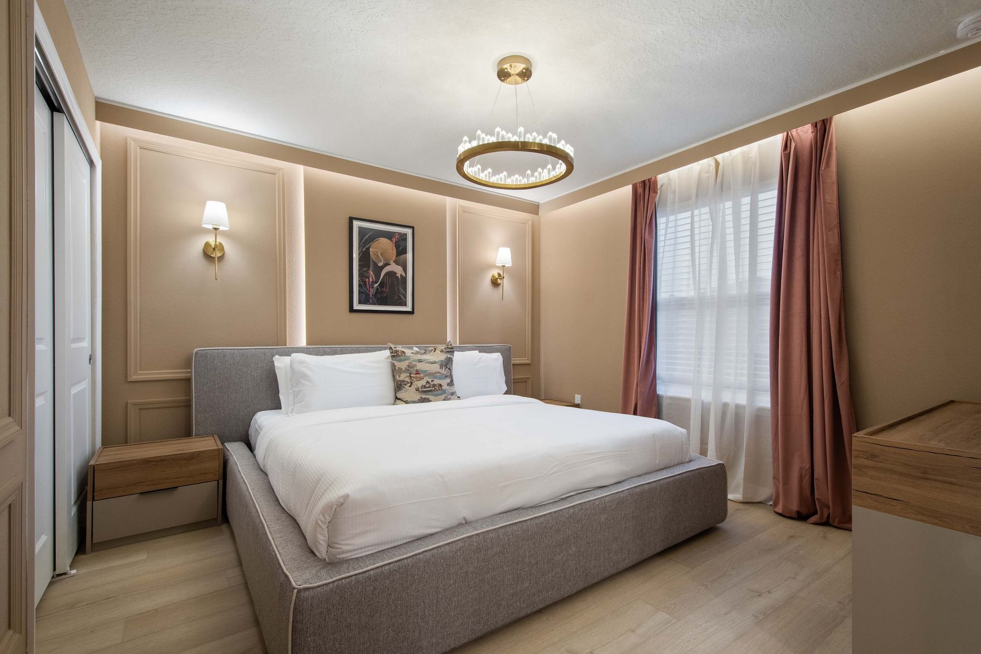 Elegant bedroom with warm tones, plush king bed, and modern classic lighting.