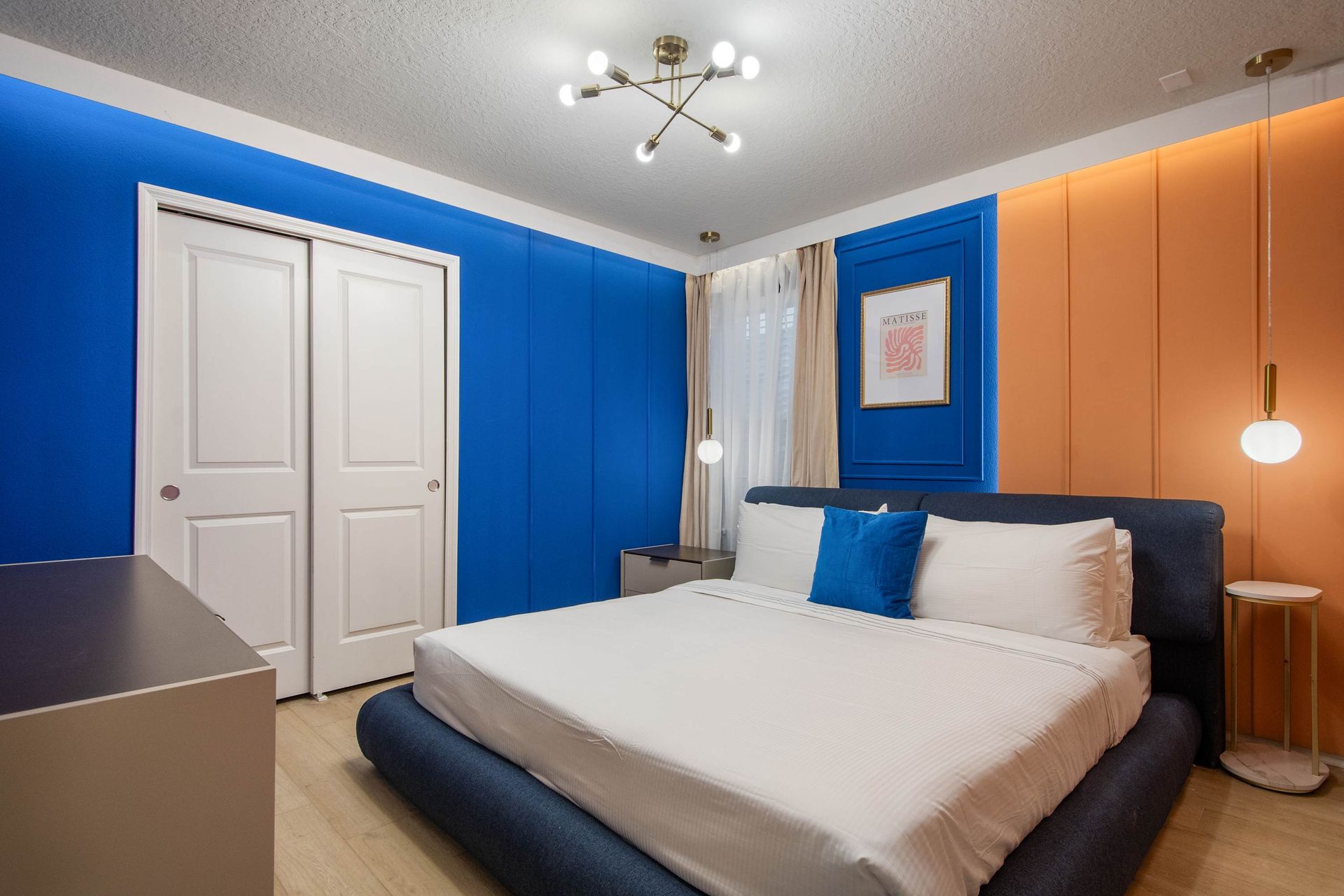 Colorful modern bedroom with bold walls, sleek lighting, and a plush king bed.