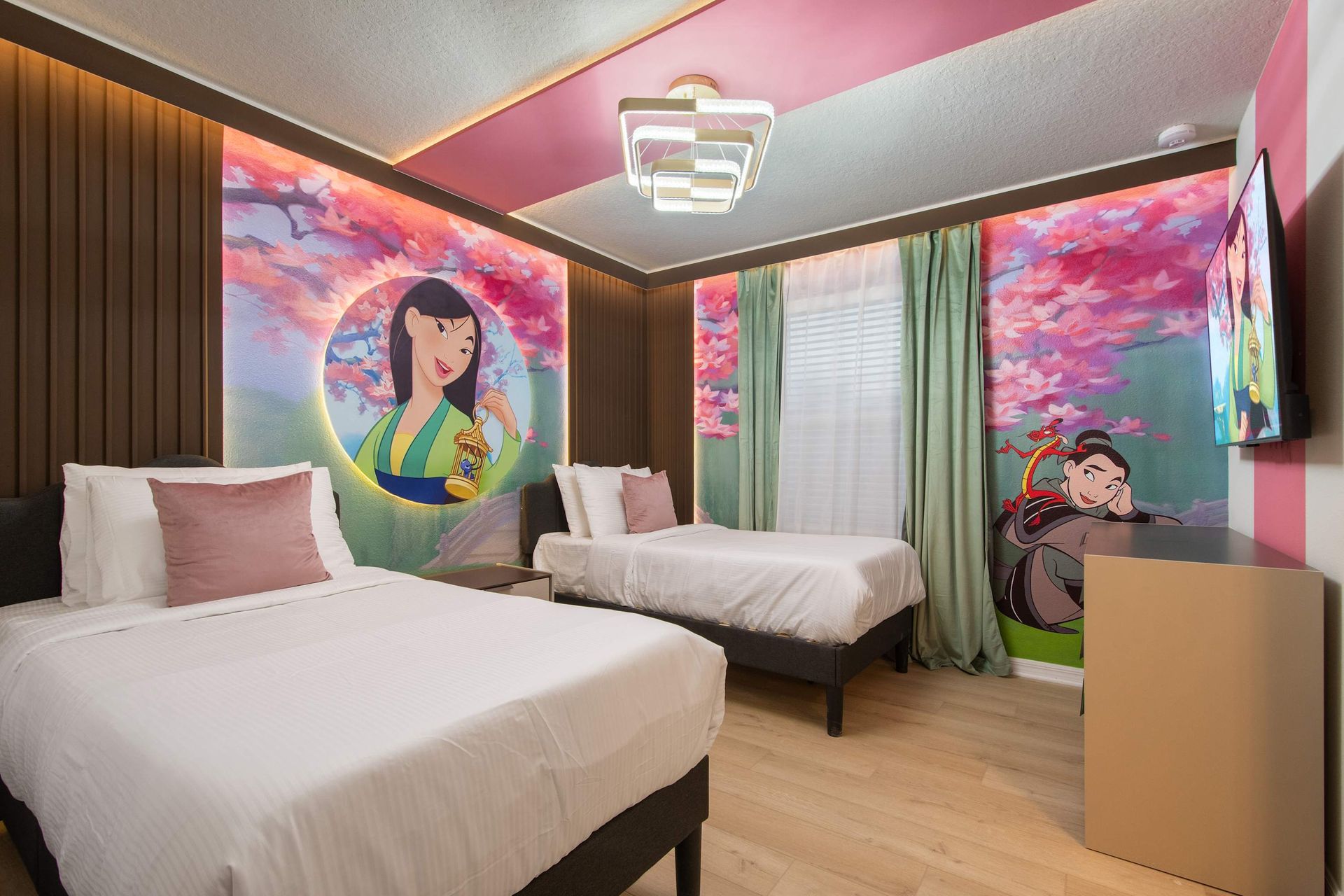 Vibrant princess-themed room with twin beds, cherry blossom murals, and charm.