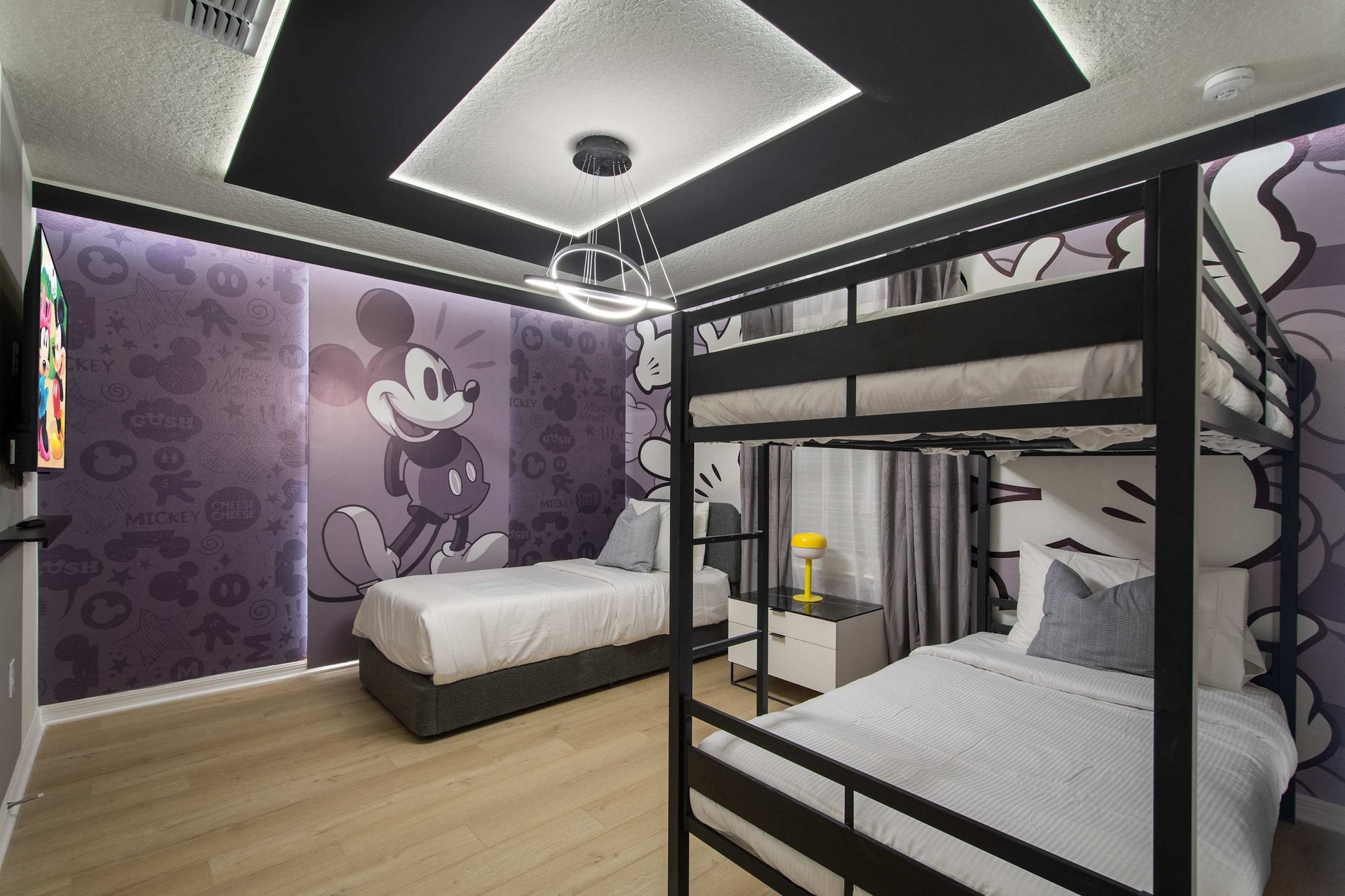 Fun cartoon-inspired bedroom with twin bed, bunk beds, and vibrant character art.