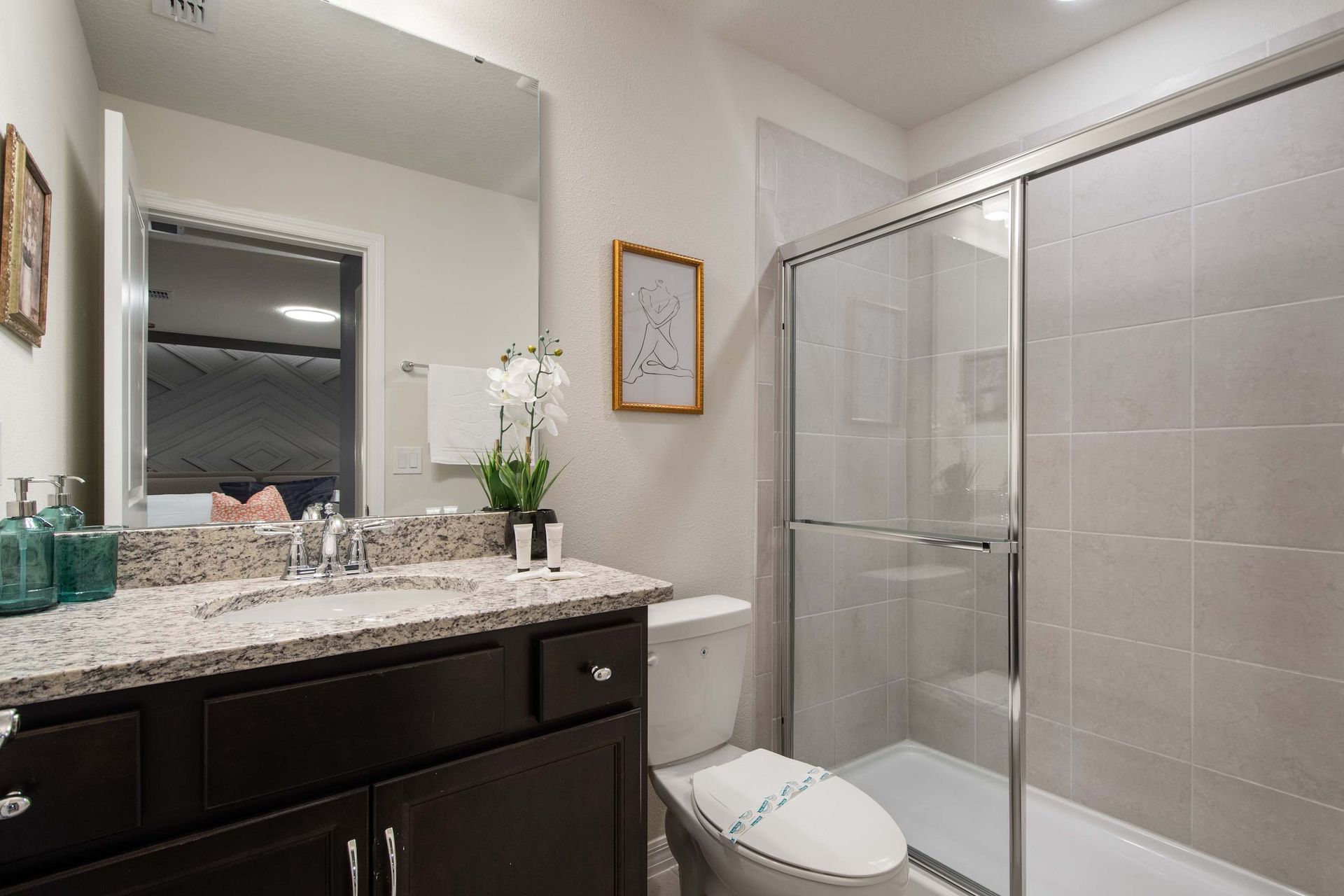 Stylish bathroom with granite countertop and sleek glass-enclosed shower.