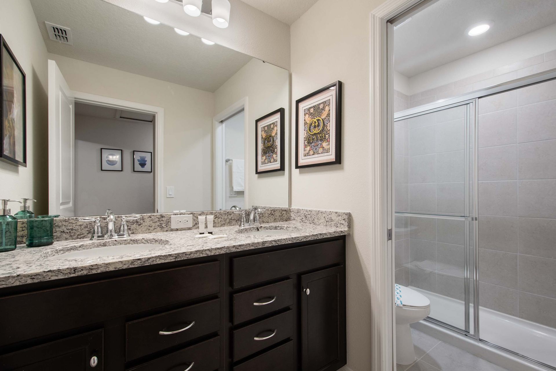 Elegant bathroom with granite countertops and a sleek glass-enclosed shower.