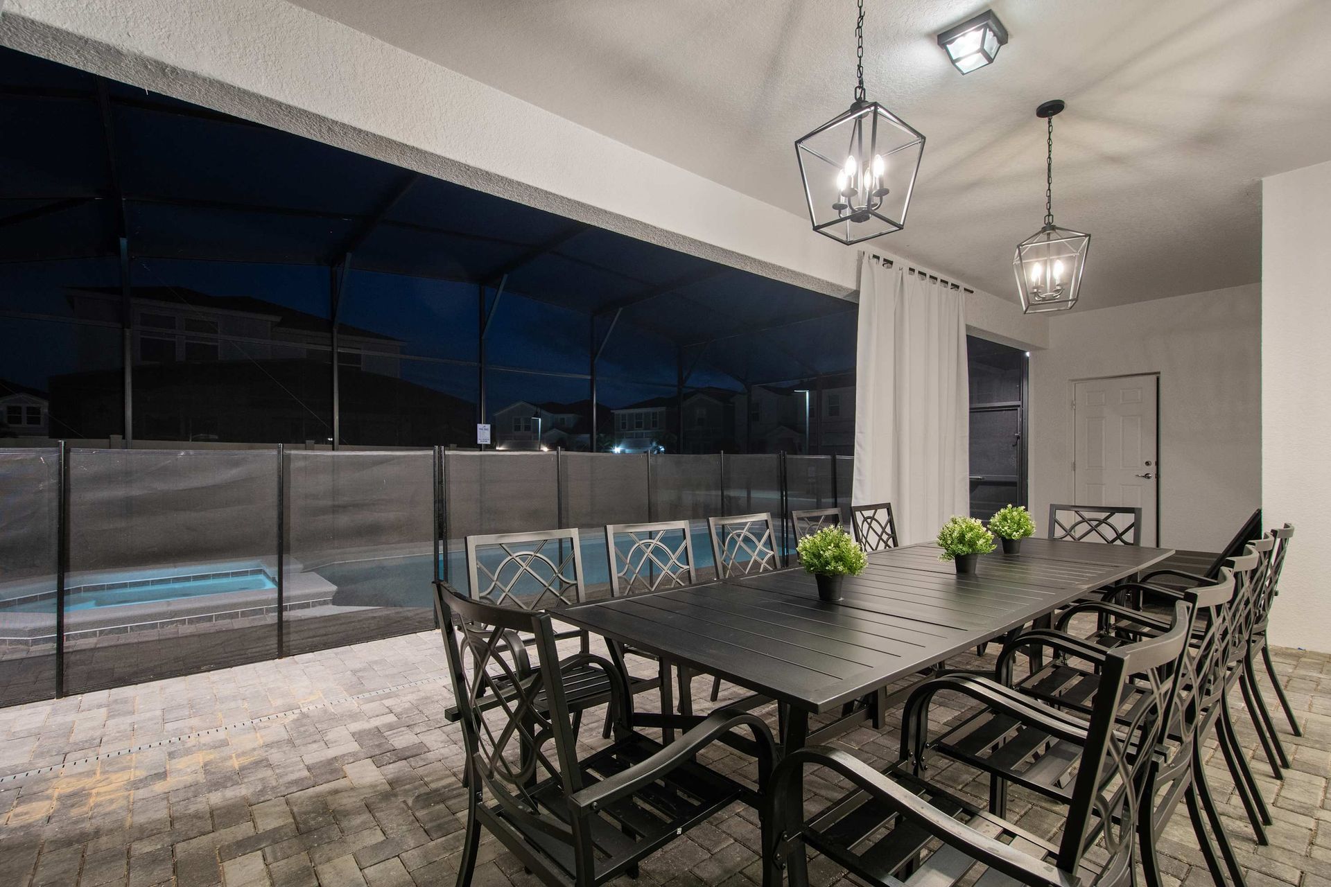Spacious screened patio with elegant dining and a view of the private pool.