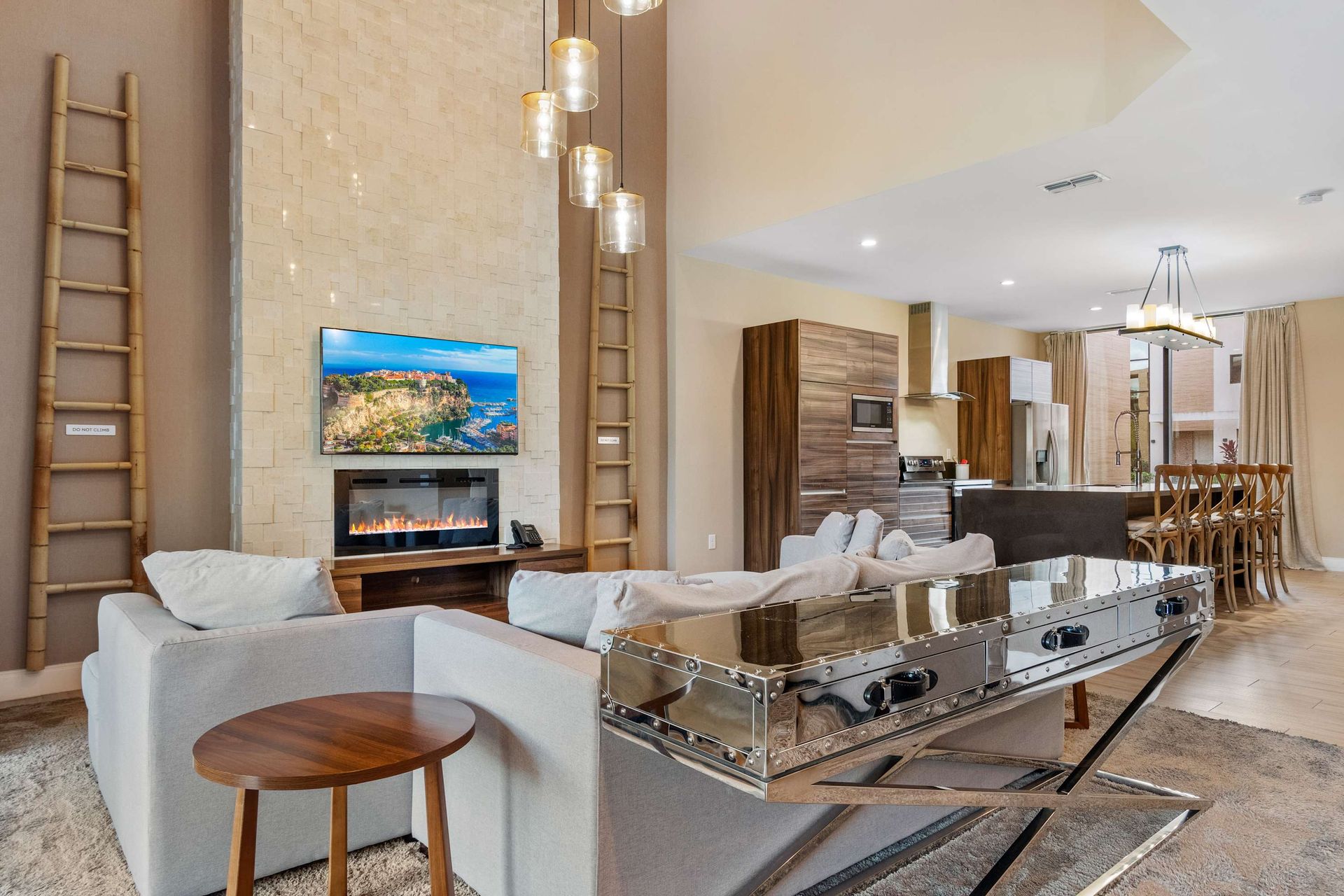 Elegant open-concept living with sleek finishes, fireplace, and designer lighting
