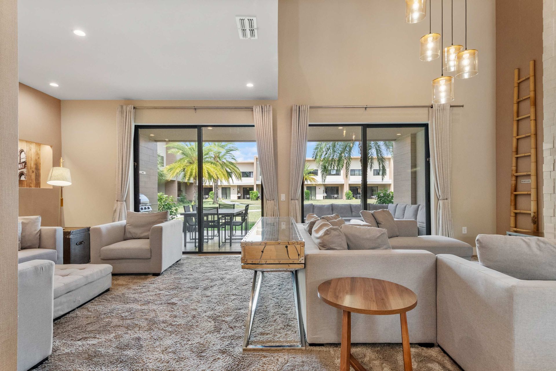 Stylish living space with cozy seating, tall ceilings, and sunny patio access
