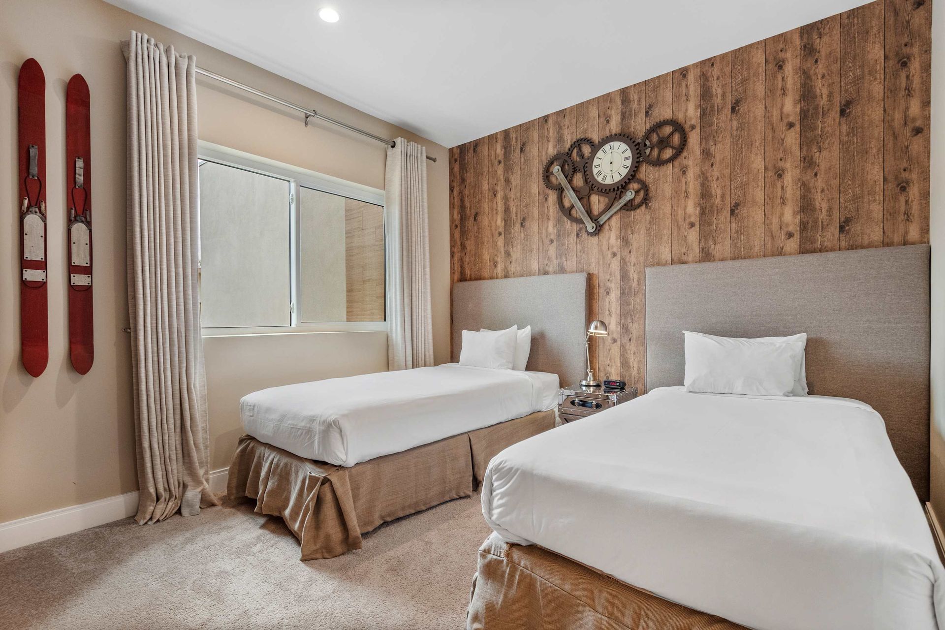 Cozy twin bedroom with industrial clock decor, rustic wood wall, and soft lighting
