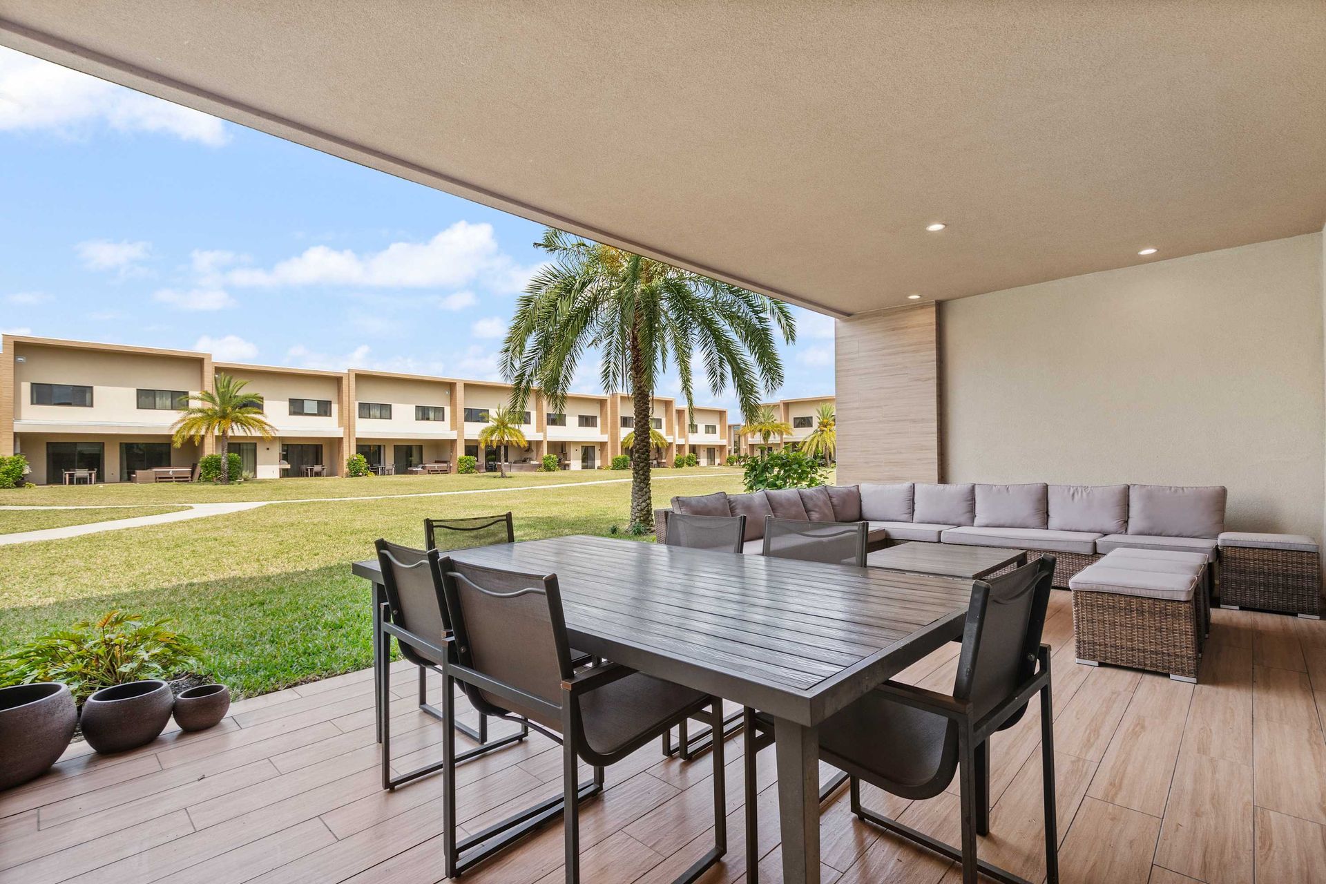 Covered outdoor oasis with dining area, comfy lounge seating, and garden views
