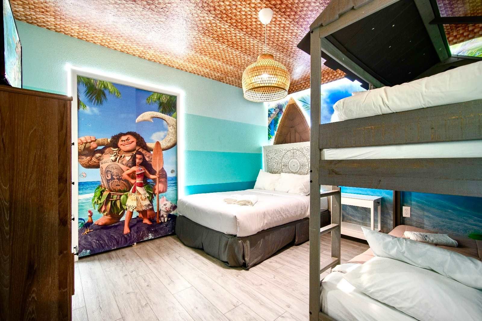 Moana-themed bedroom with bunk beds and vibrant ocean wall art.