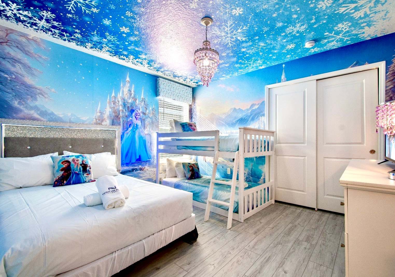 Whimsical Frozen-themed room with snowflake ceiling, castle murals, and bunk beds