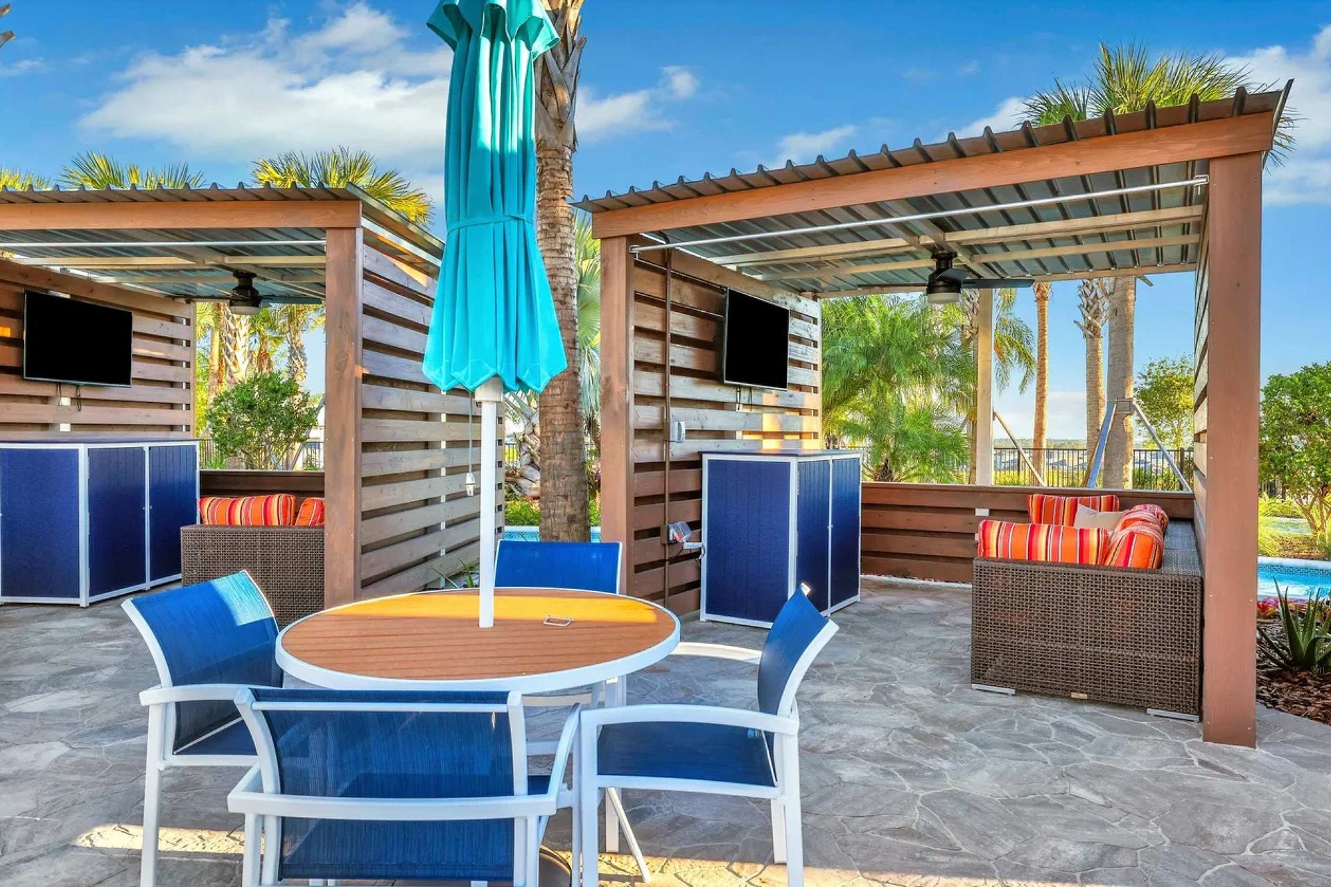 Private cabana with comfy seating, TV, ceiling fan, and relaxing poolside views
