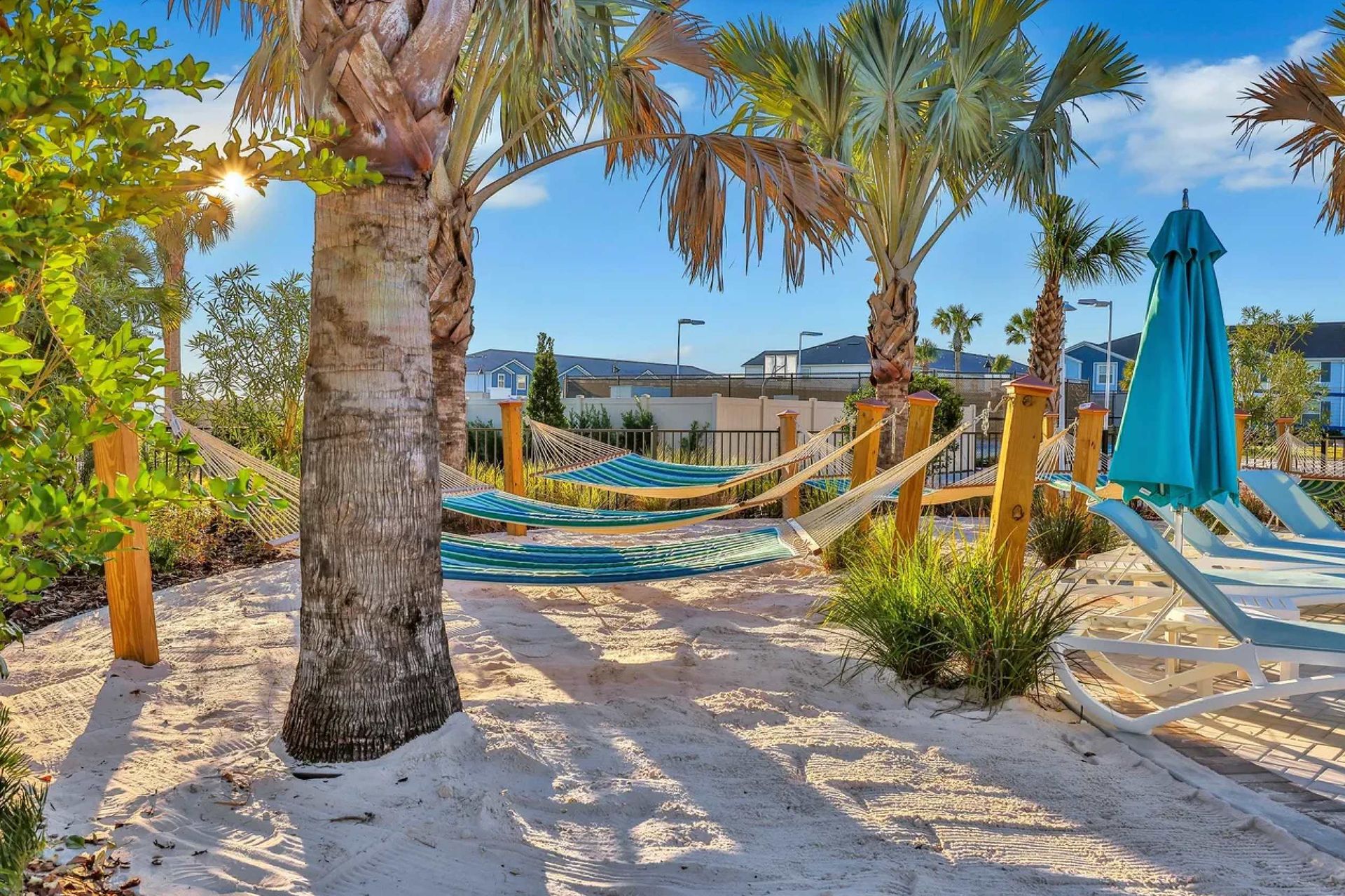 Tropical hammock garden with soft sand, palm trees, and relaxing shaded loungers
