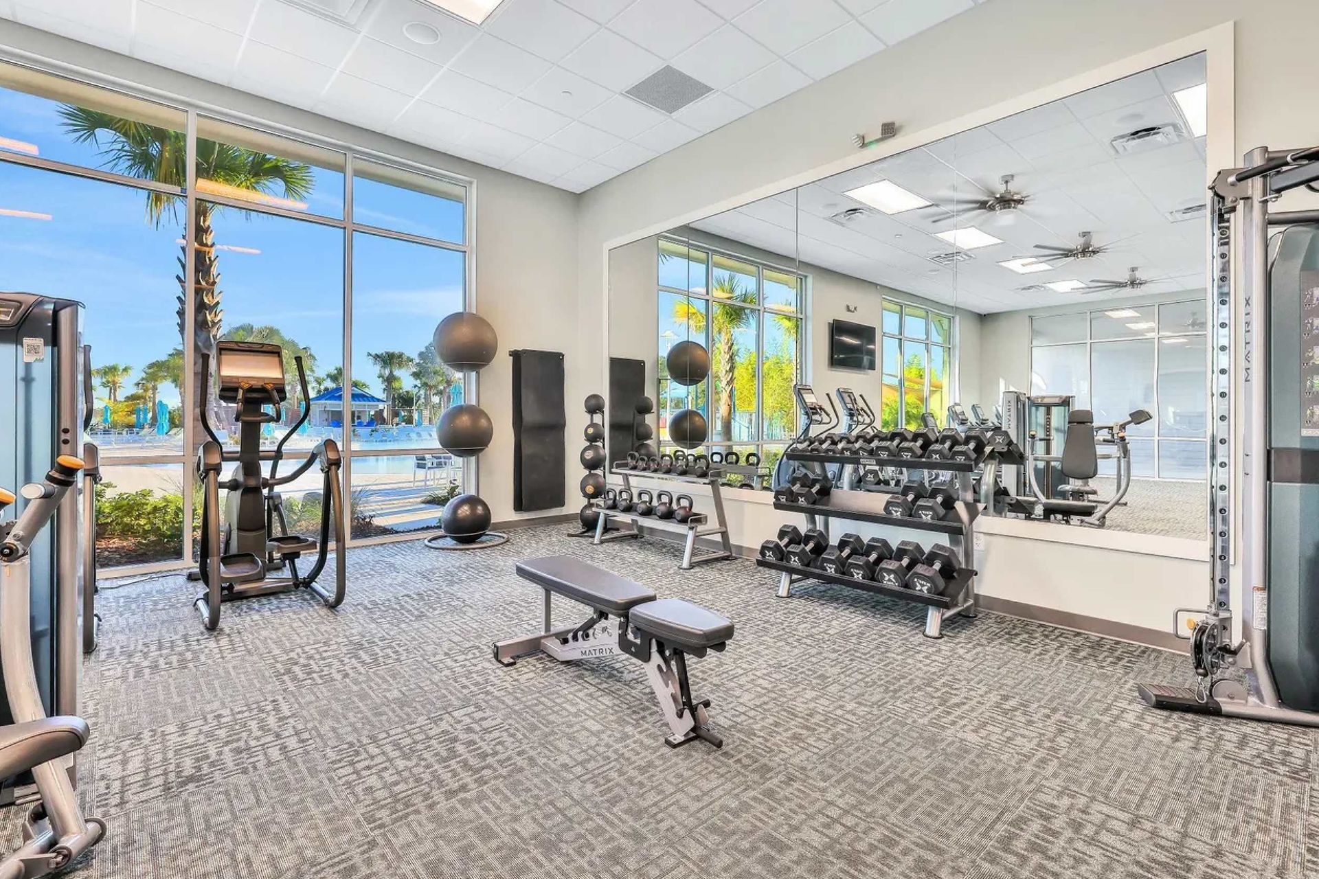 State-of-the-art fitness center with cardio machines, weights, and poolside views.