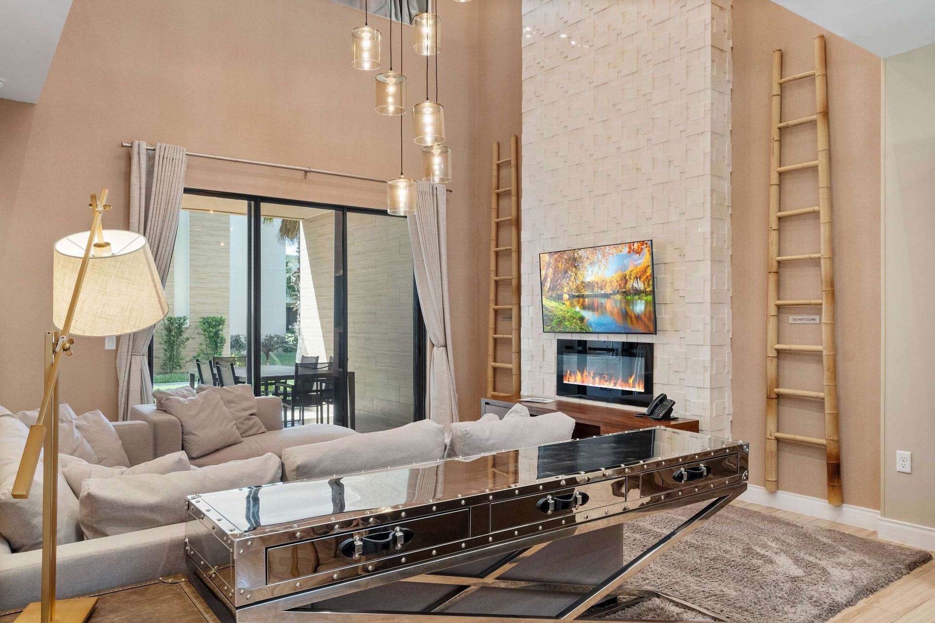 Chic living space with mirrored coffee table, cozy fireplace, and tall ceilings
