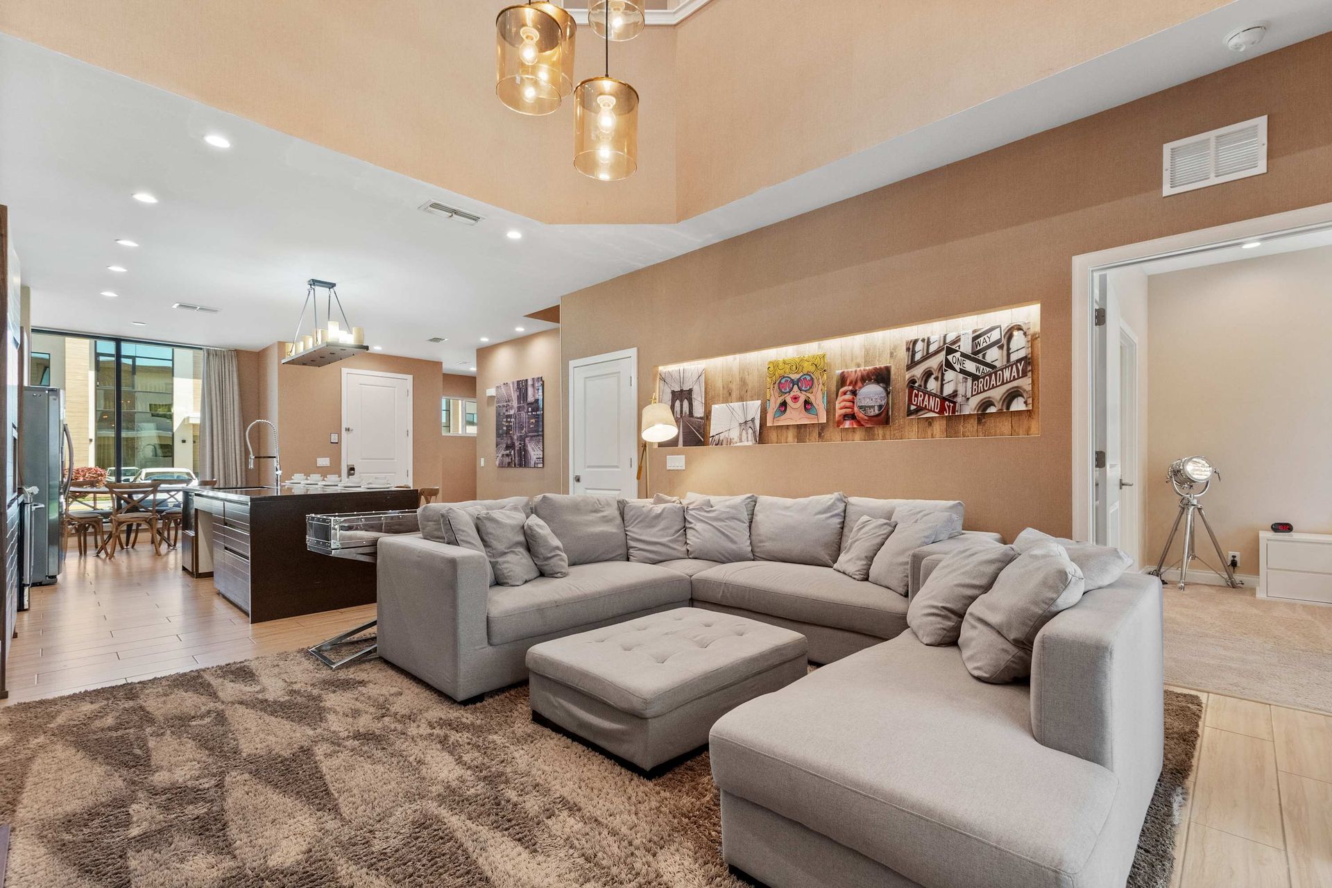 Spacious lounge with plush sectional, modern art, and seamless open layout living
