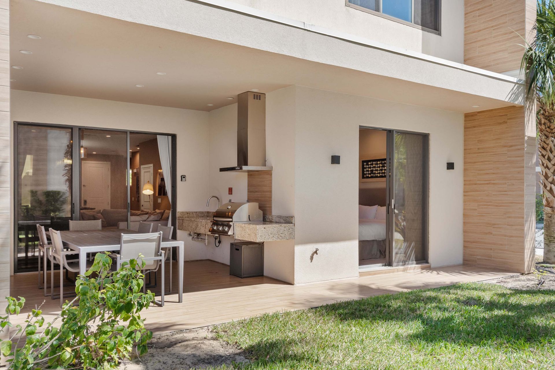 Covered patio with built-in grill, outdoor dining, and direct indoor access
