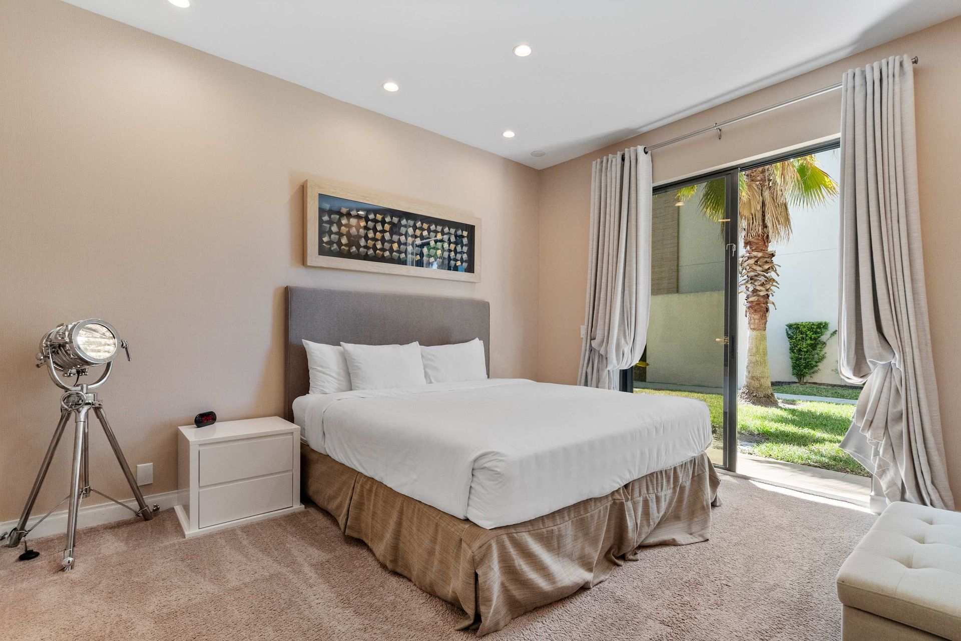 Tranquil bedroom with plush carpet, patio access, and soft natural lighting
