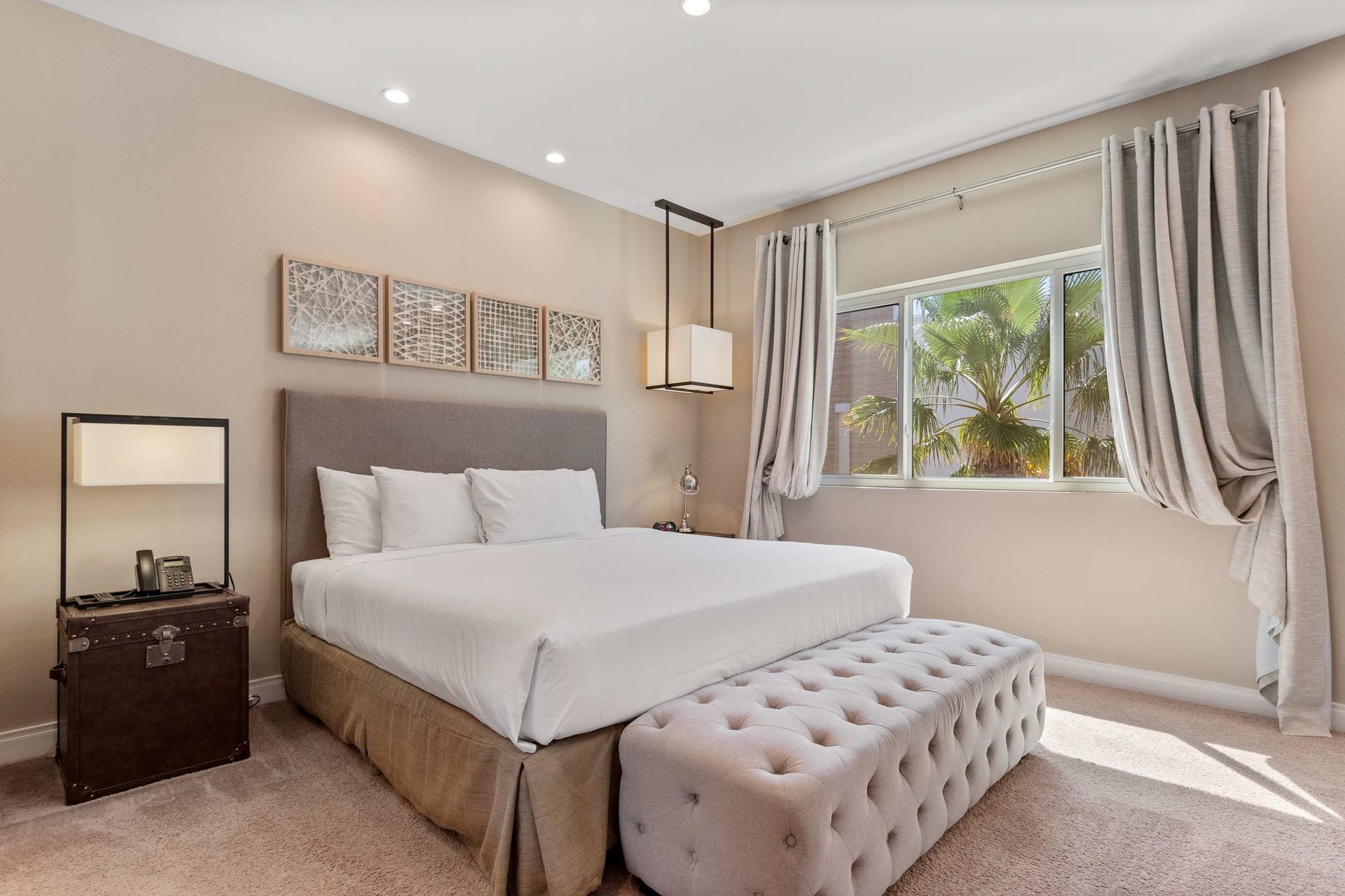 Elegant bedroom retreat with tufted bench, soft lighting, and garden window views
