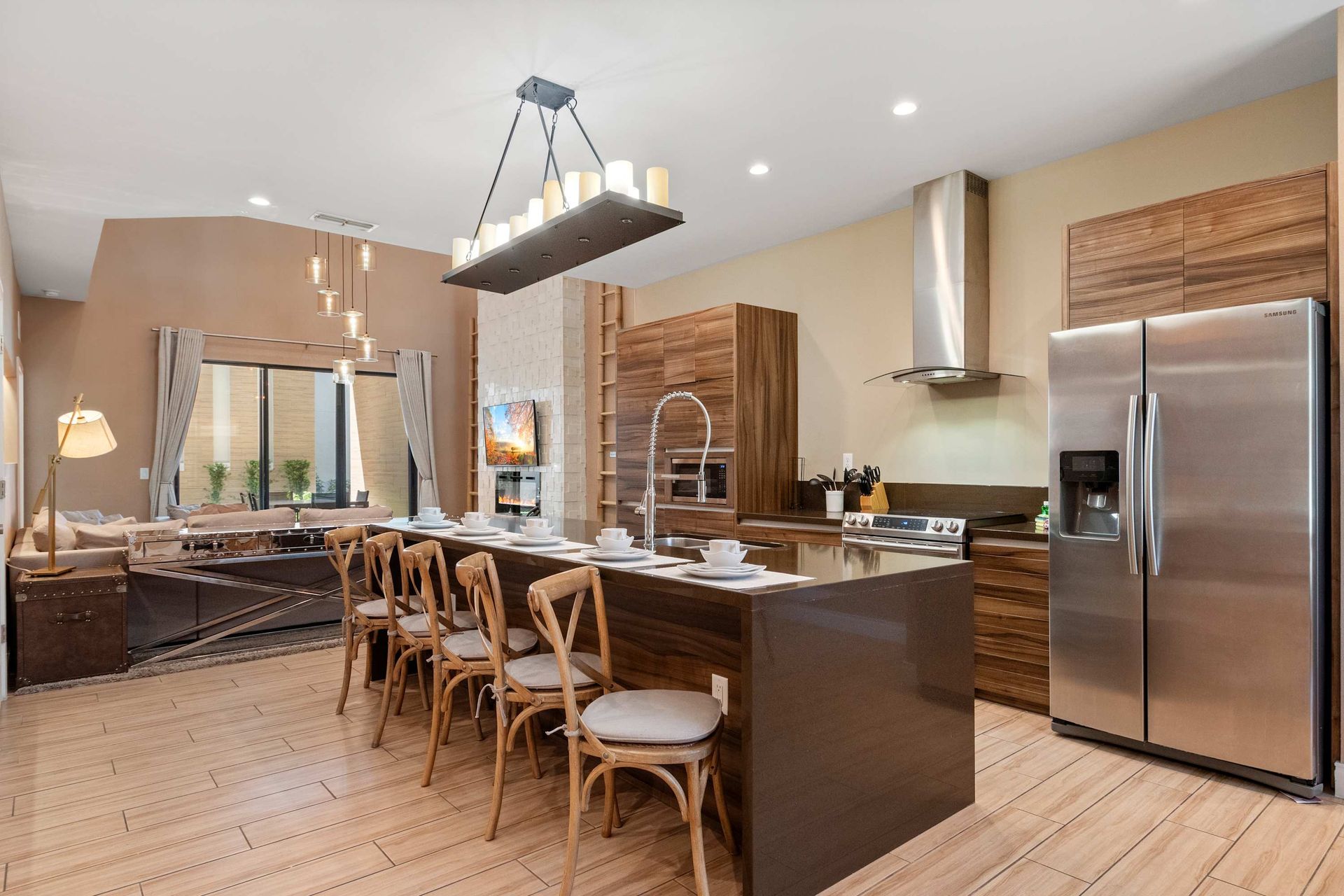 Modern gourmet kitchen with stainless appliances, island seating, and wood accents
