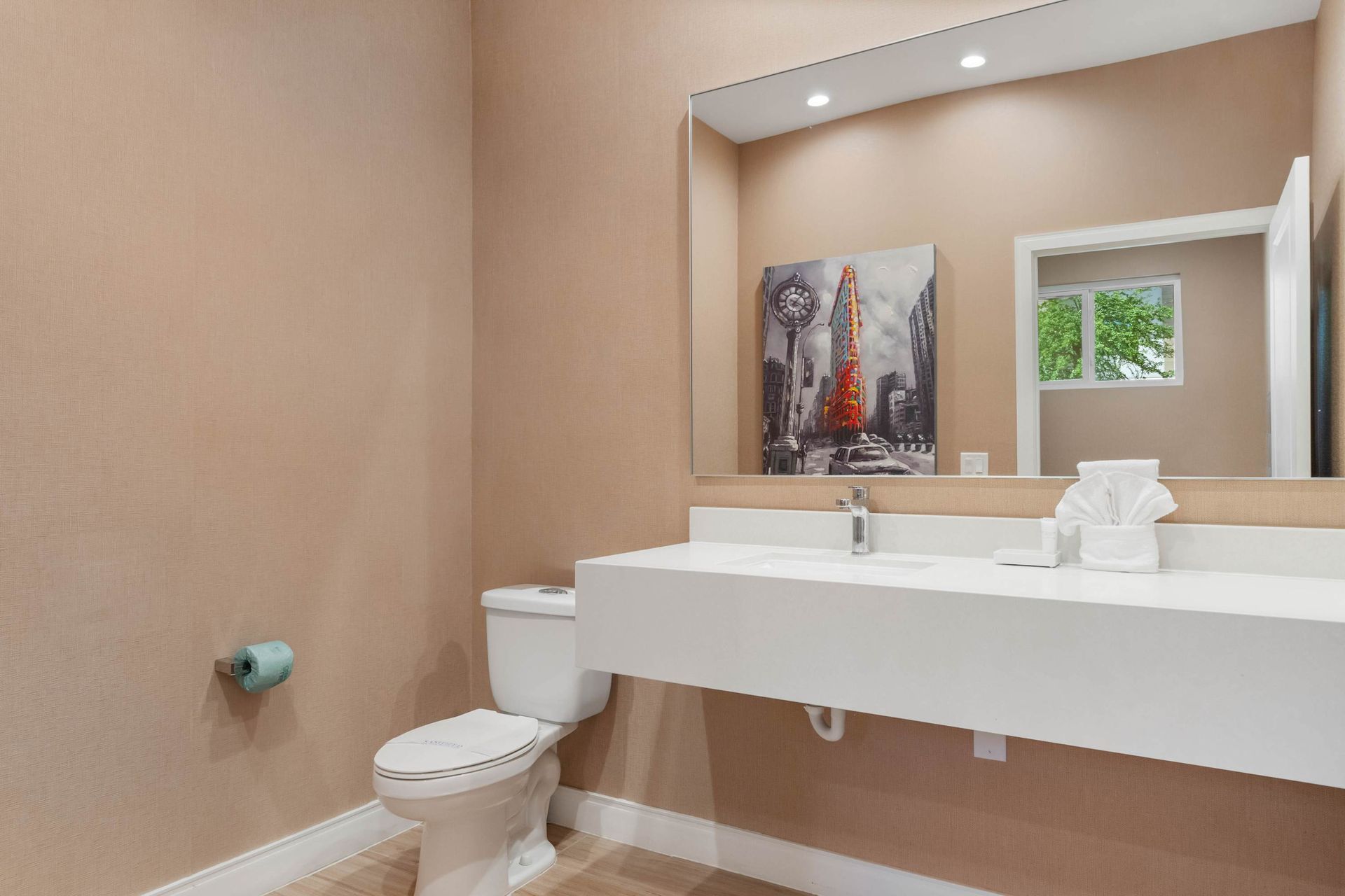 Contemporary half bath with sleek floating vanity, bold wall art, and soft lighting
