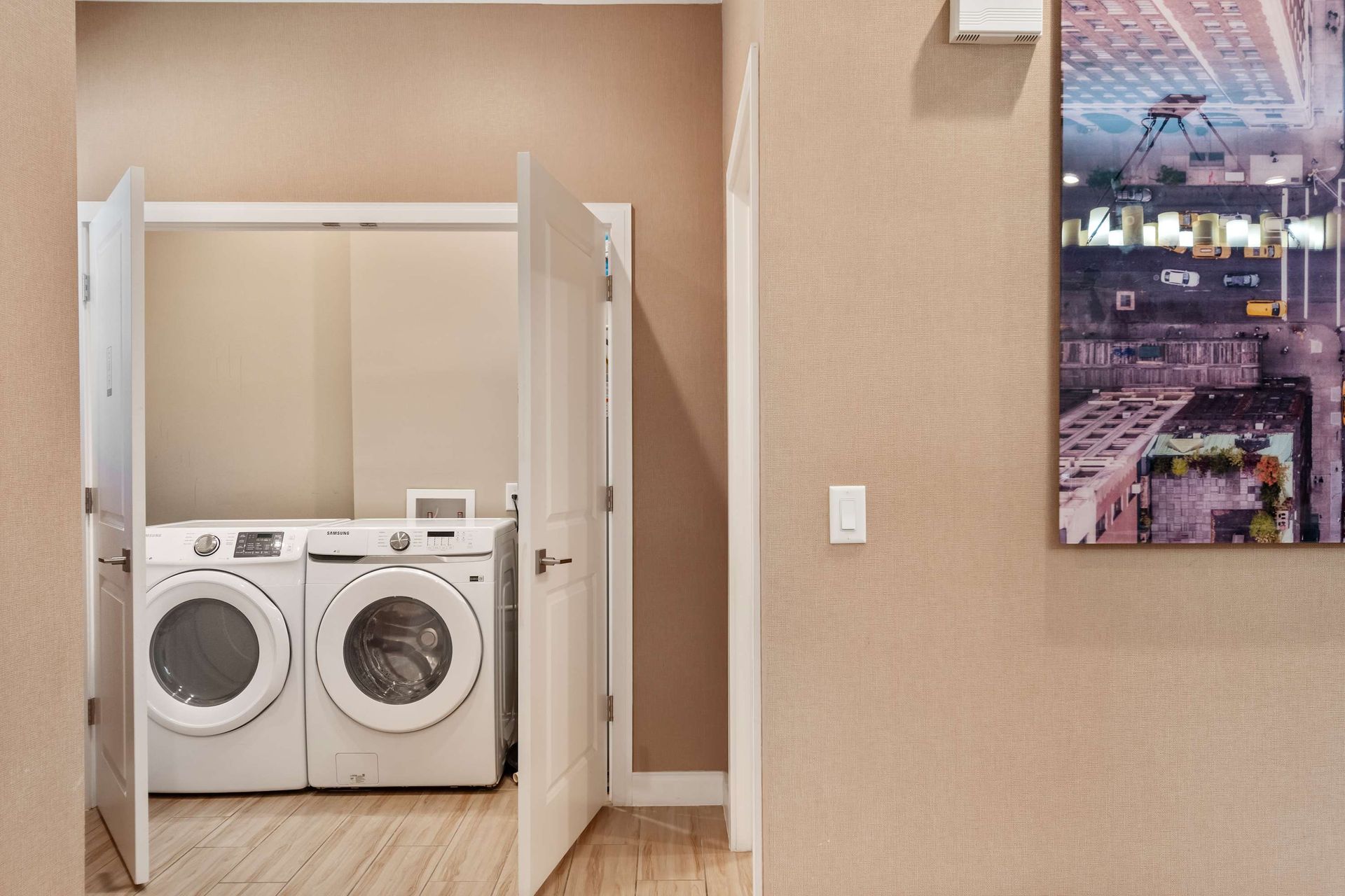 In-unit laundry with full-size washer and dryer, tucked neatly behind double doors
