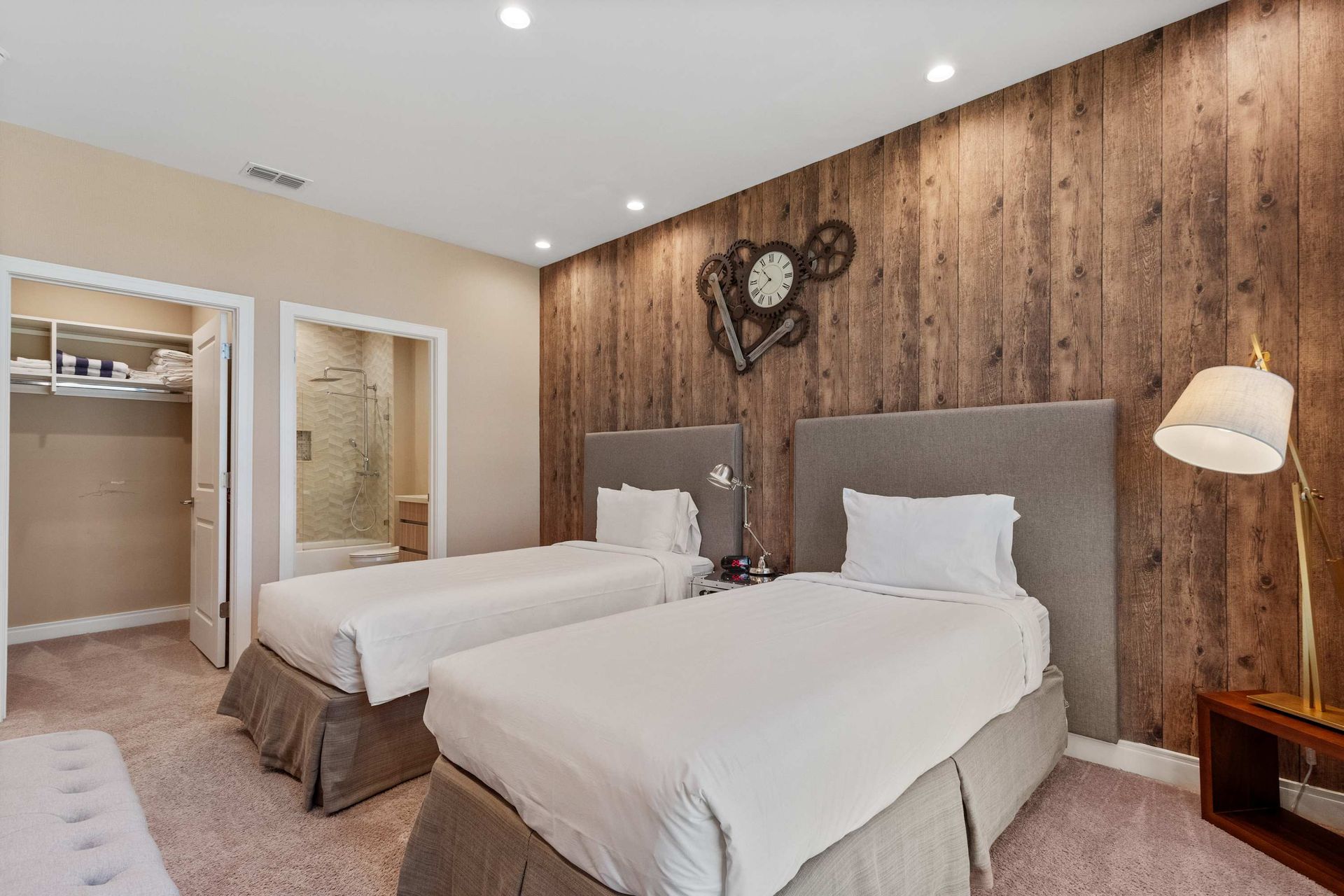 Charming twin bedroom with rustic accent wall, cozy lighting, and walk-in closet
