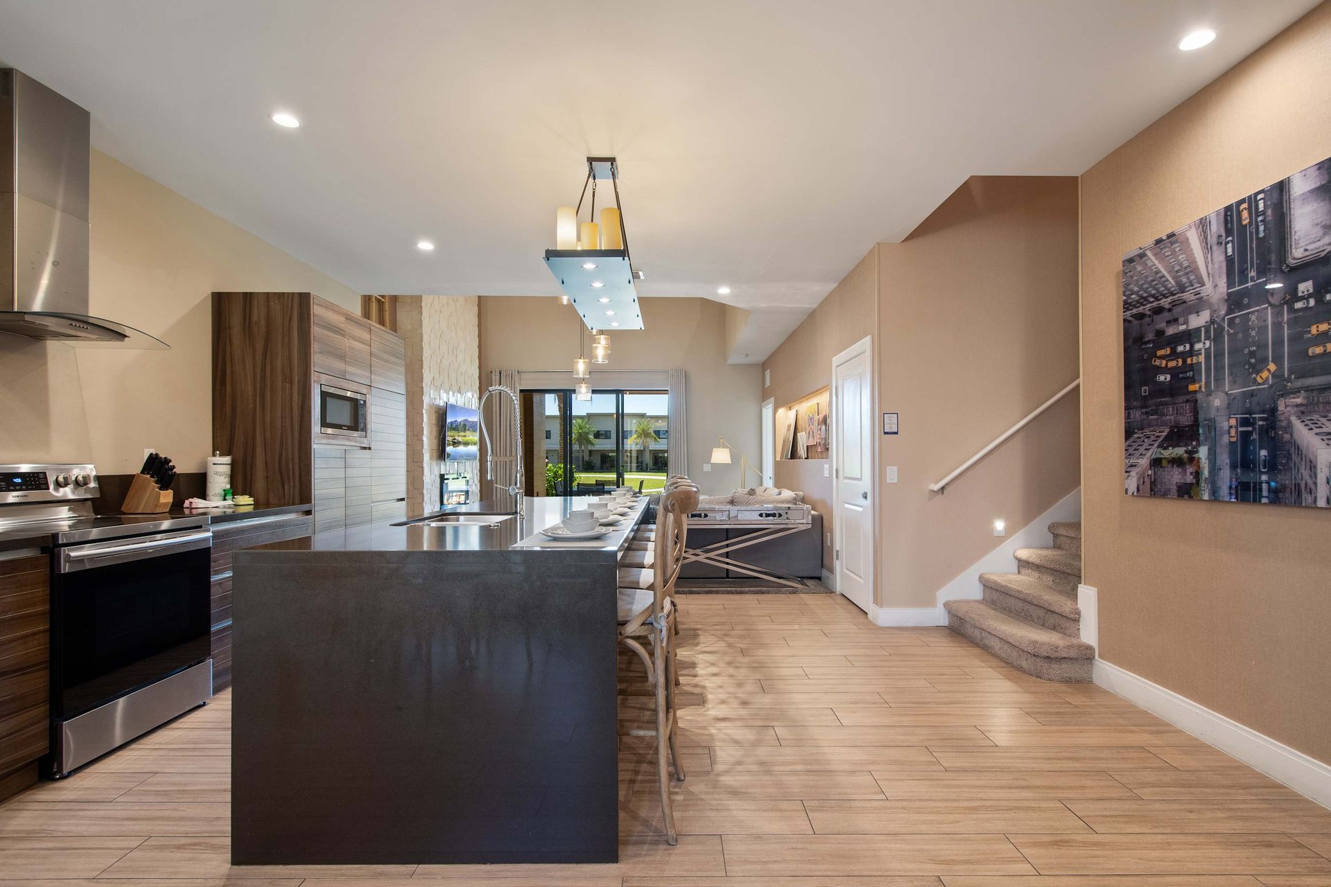 Modern open kitchen with sleek island, stylish dining, and bright living space.
