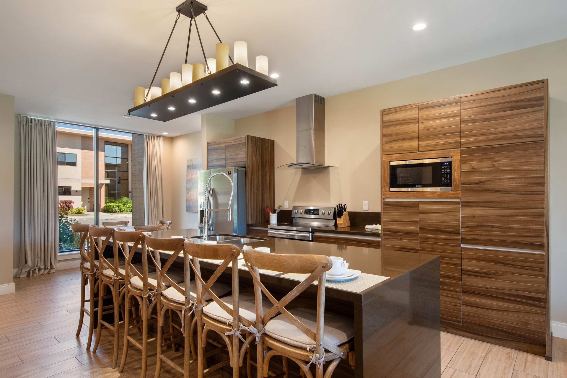 Elegant kitchen with wood cabinetry, spacious island seating, and bright patio access.
