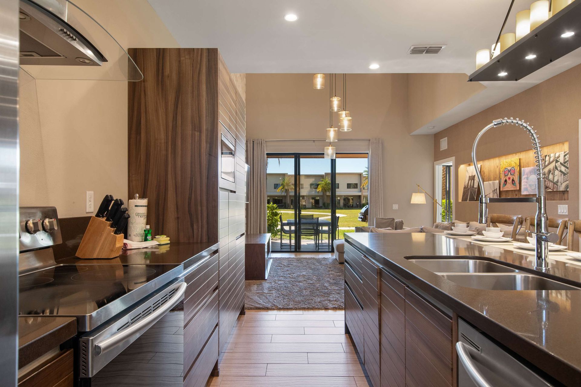 Sleek gourmet kitchen with double ovens, large island, and open living patio view.
