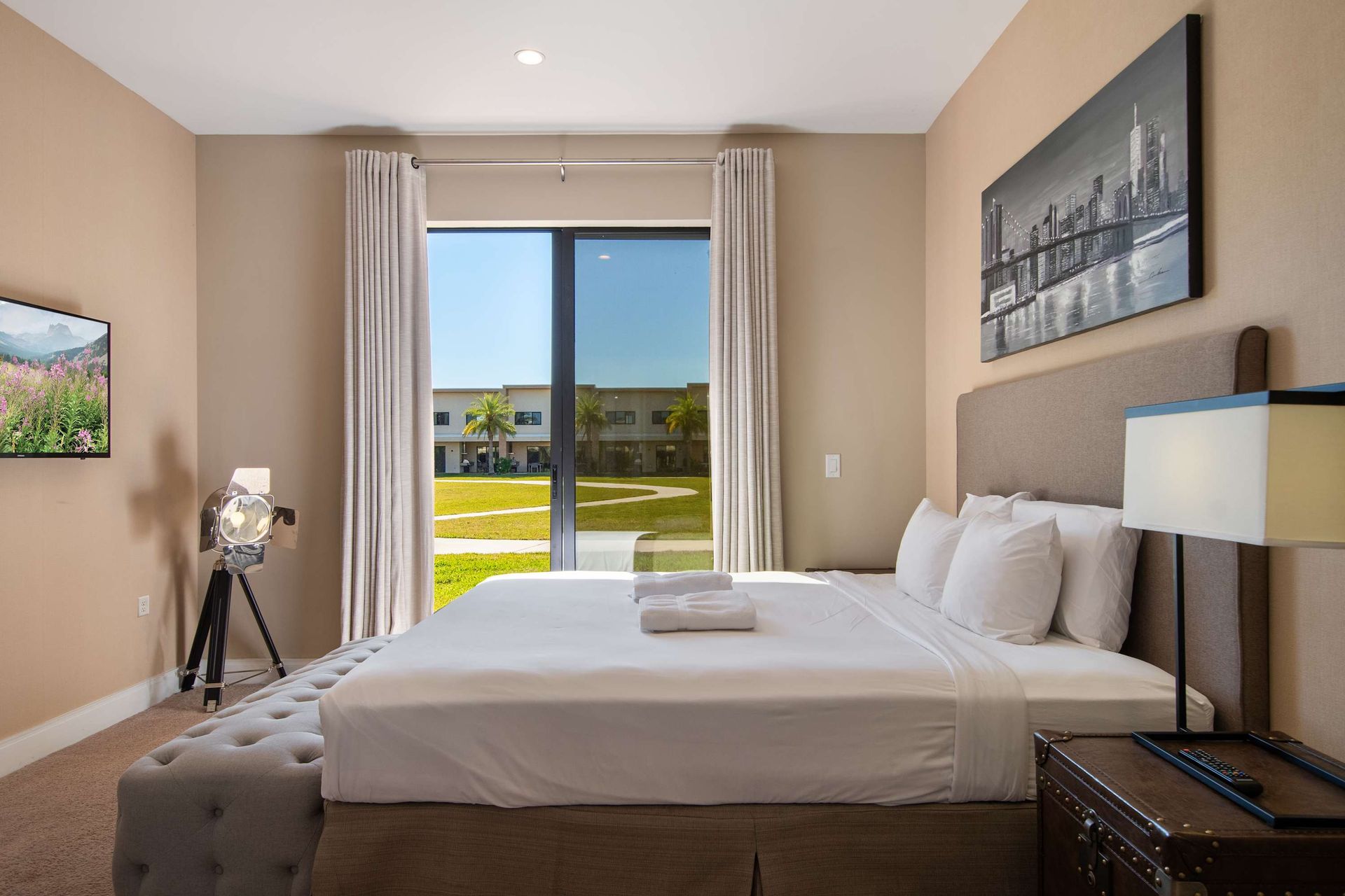 Relaxing bedroom with king bed, stylish decor, patio access, and garden courtyard view.
