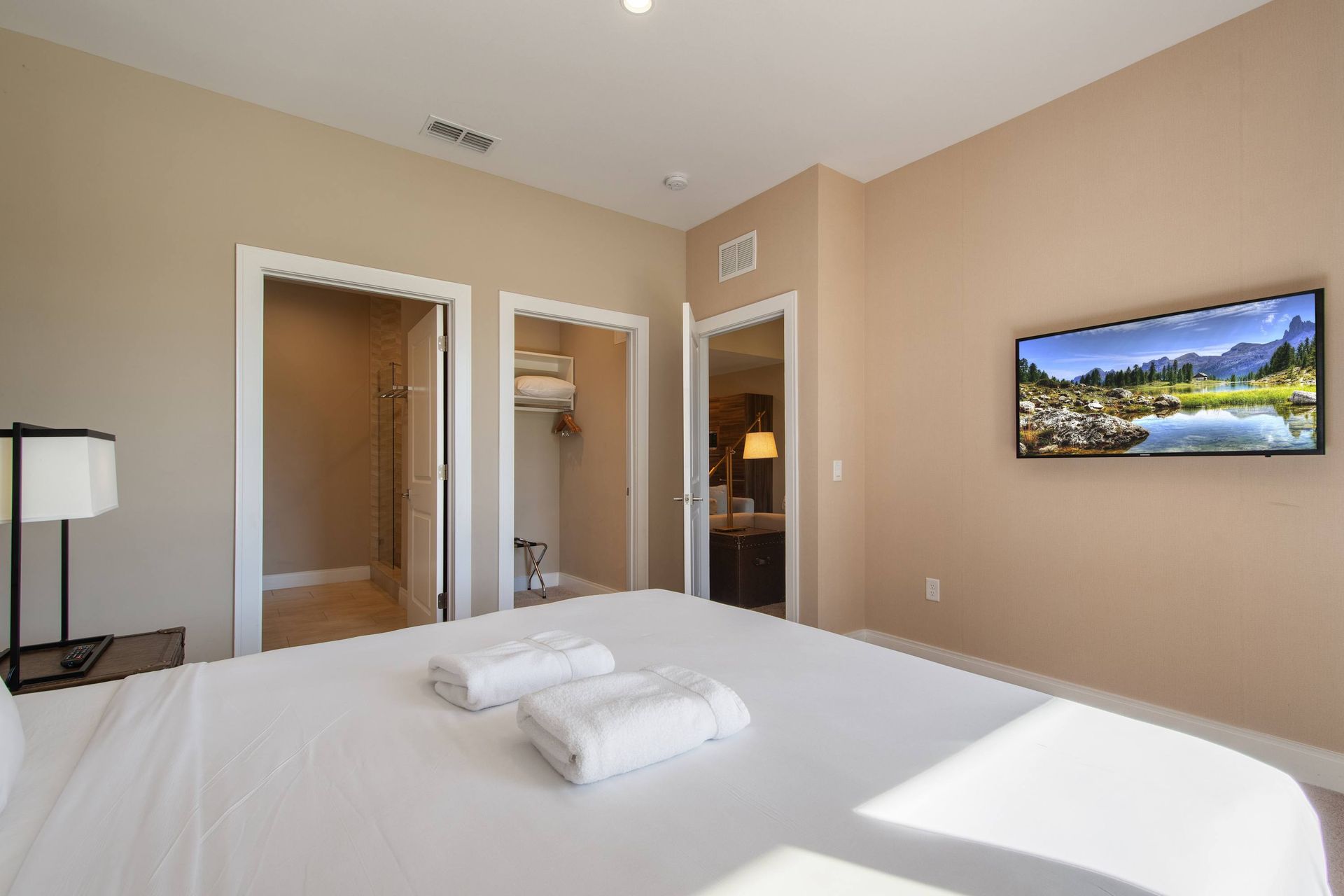 Bright master bedroom with ensuite bath, walk-in closet, and relaxing modern decor.
