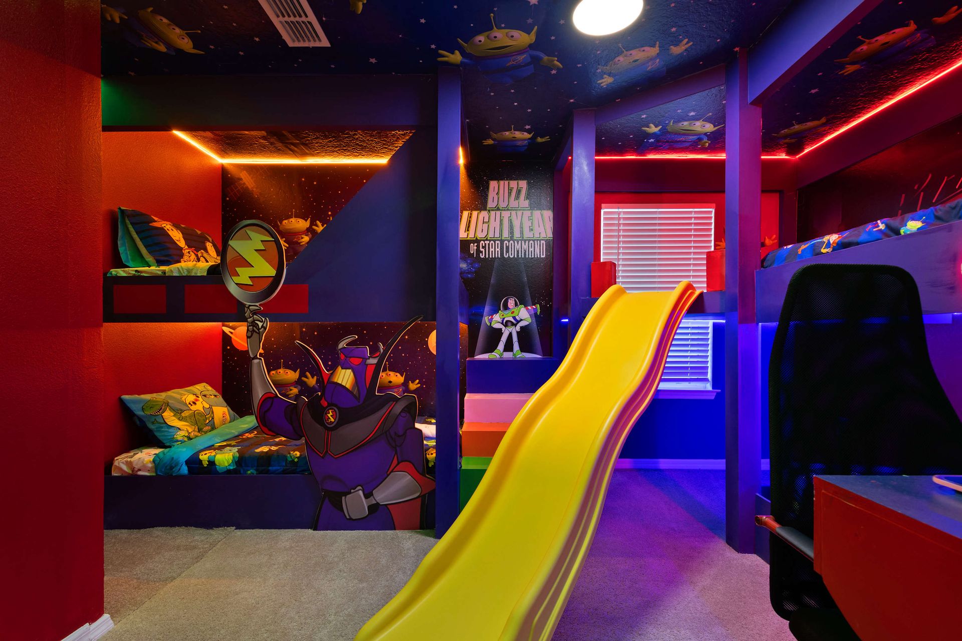 Buzz Lightyear-themed bunk room with slide, starry ceiling, and gaming zone.

