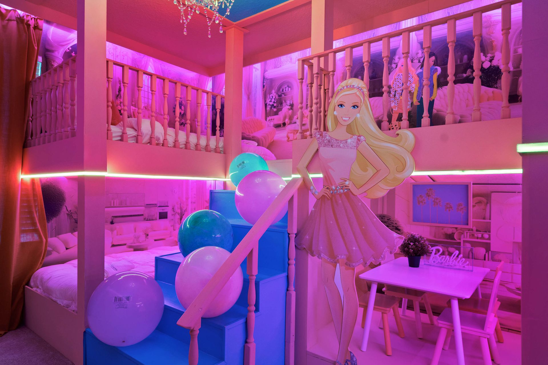 Dreamy Barbie-themed bunk room with chandeliers, play space, and pink lighting.

