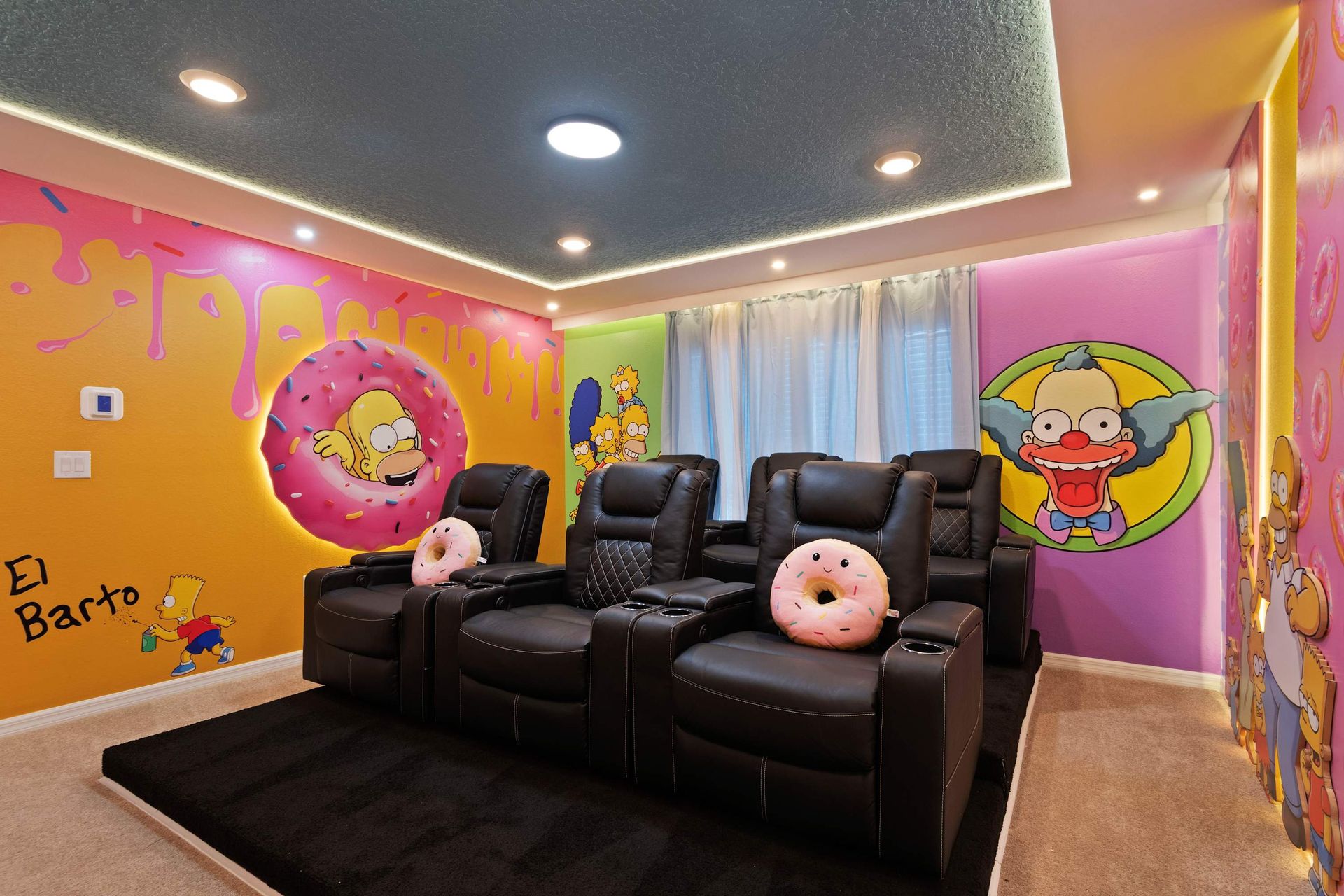 Simpsons-themed home theater with comfy recliners, donut pillows, and fun art.
